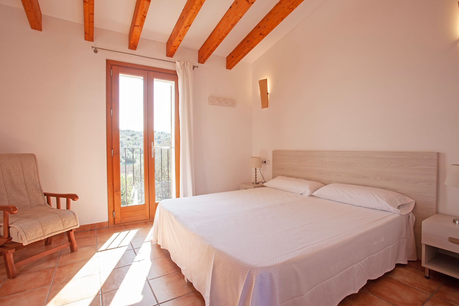 Ein Schlafzimmer mit einem Kingsize-Bett und einem Sessel