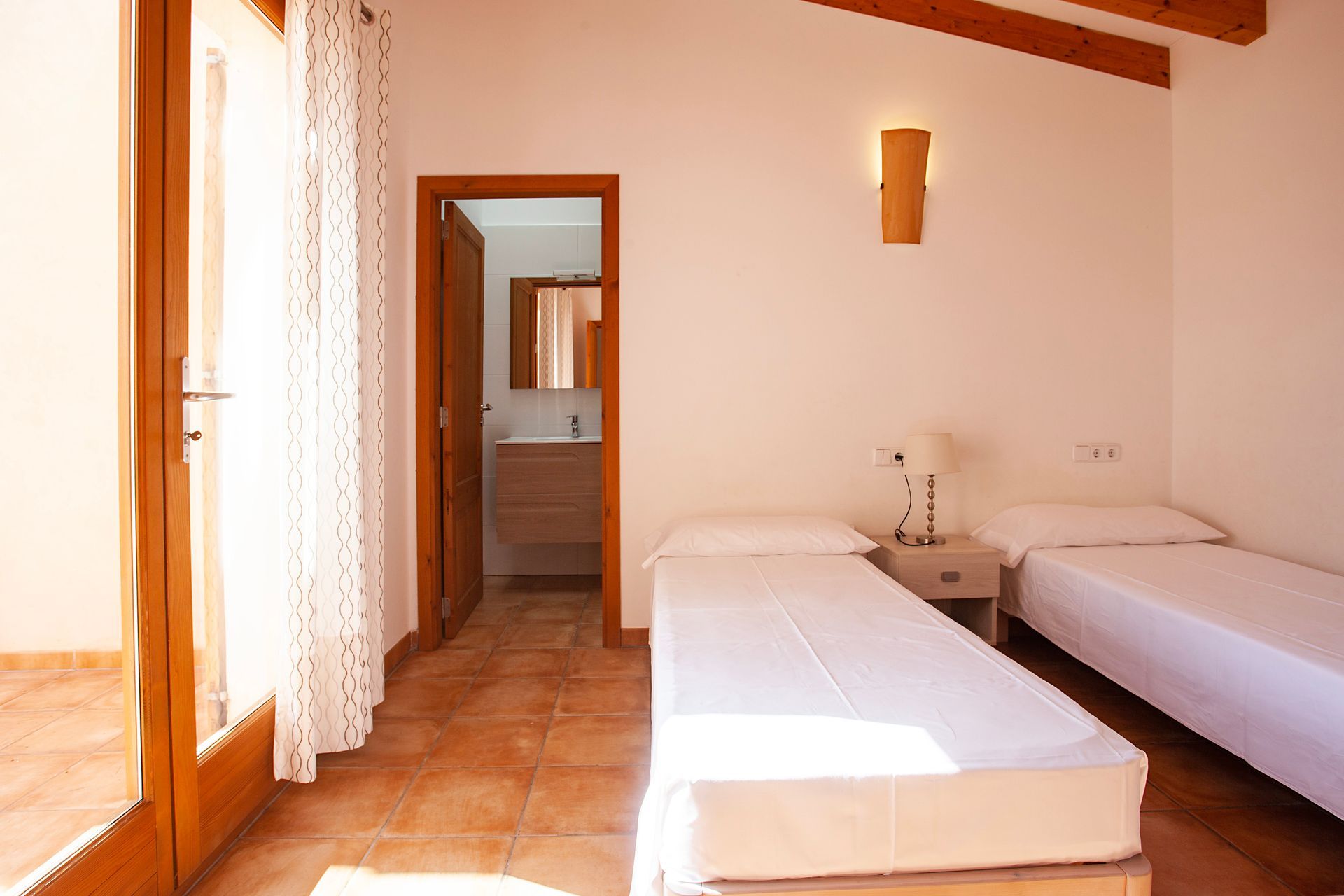 Un dormitorio con dos camas y una puerta que conduce a un baño.