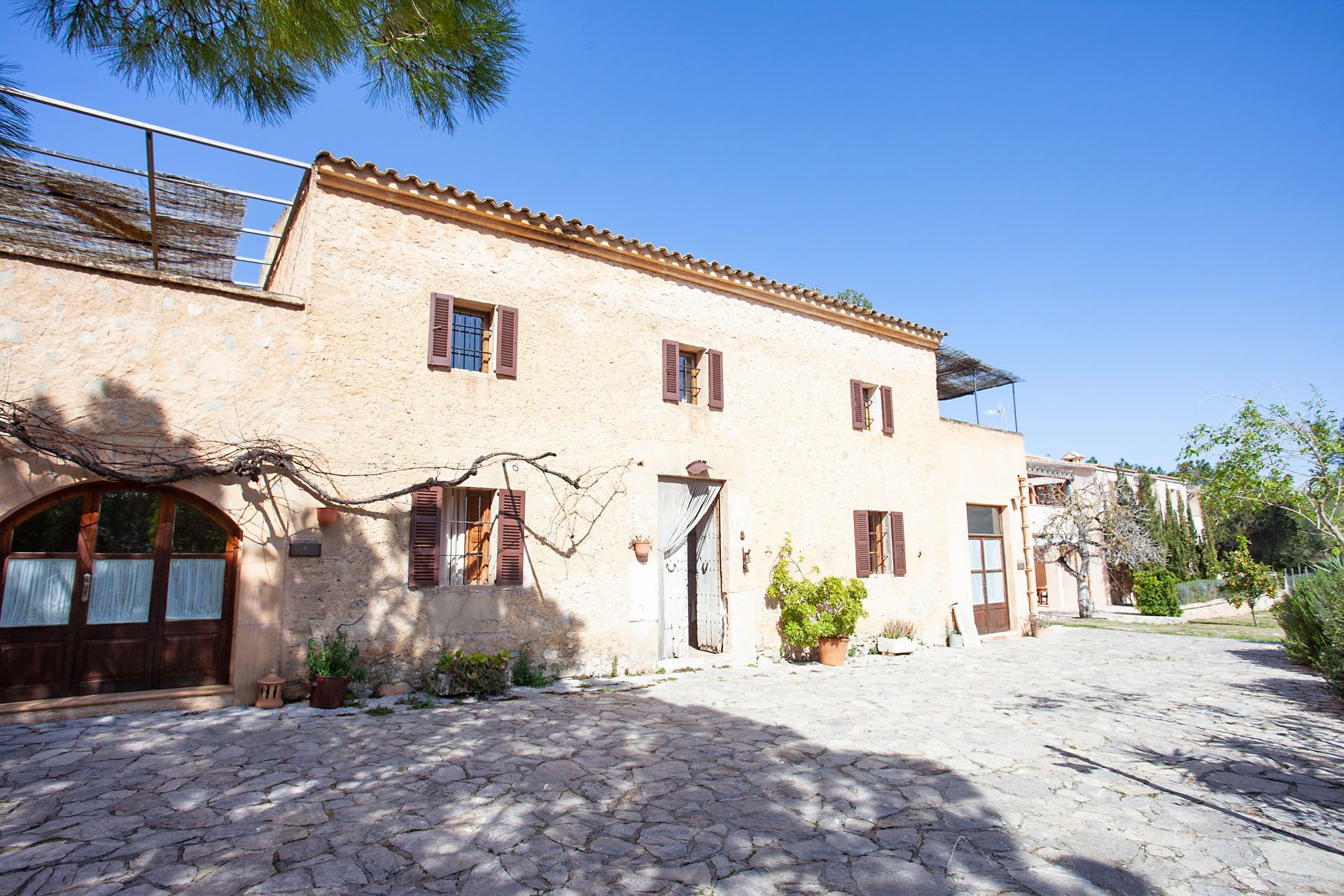 Ein großes Haus mit vielen Fenstern und einer Steinauffahrt