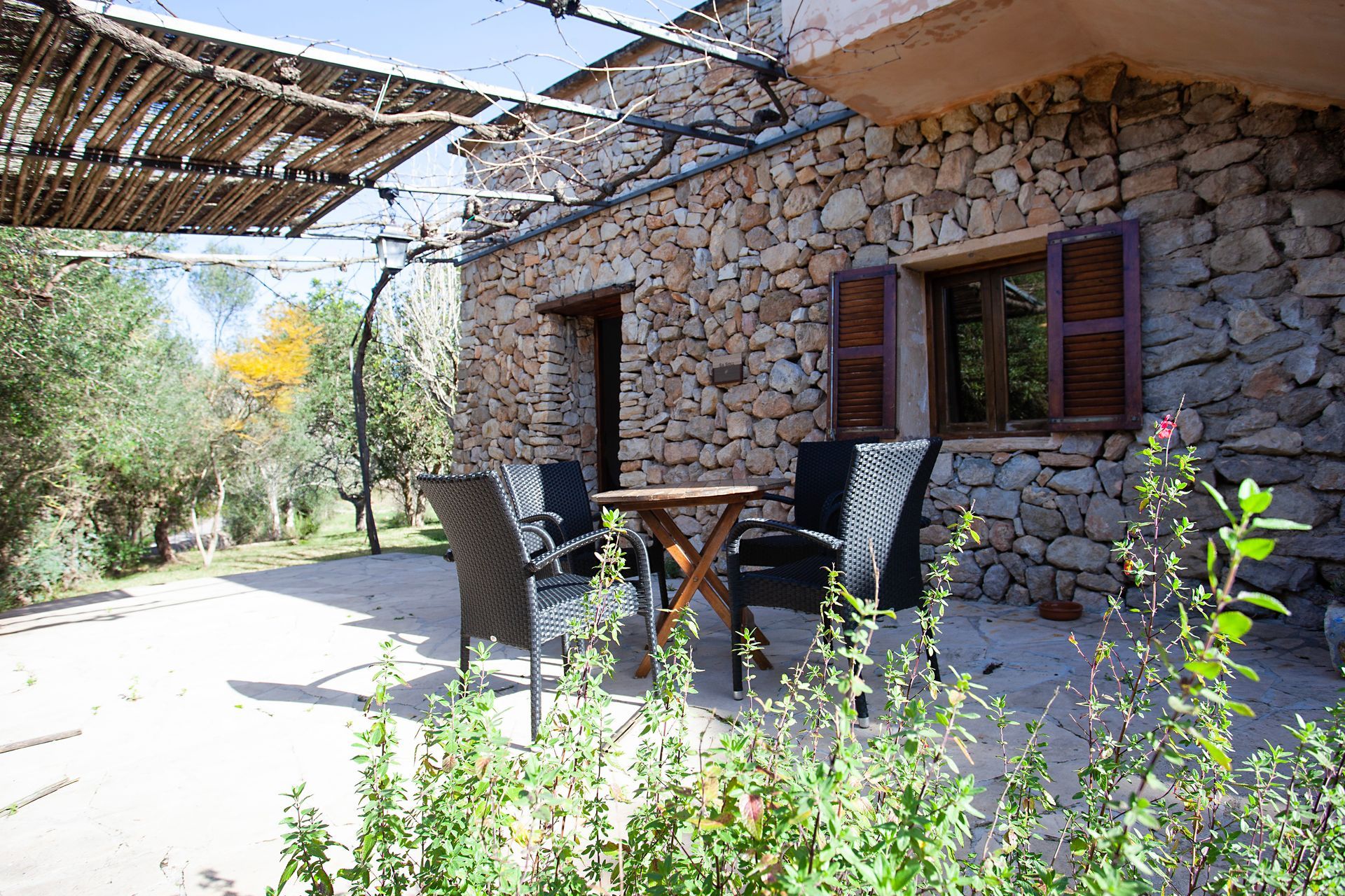 Ein Steingebäude mit einem Tisch und Stühlen davor