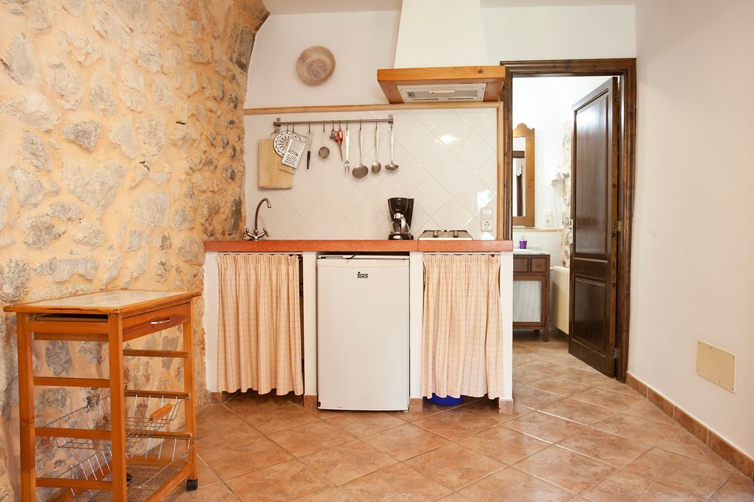 Una pequeña cocina con refrigerador, fregadero y estufa.