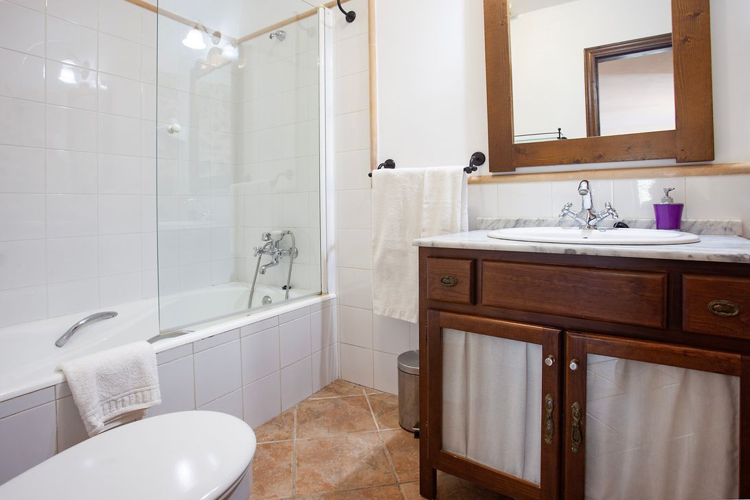 Un baño con lavabo, inodoro, bañera y espejo.