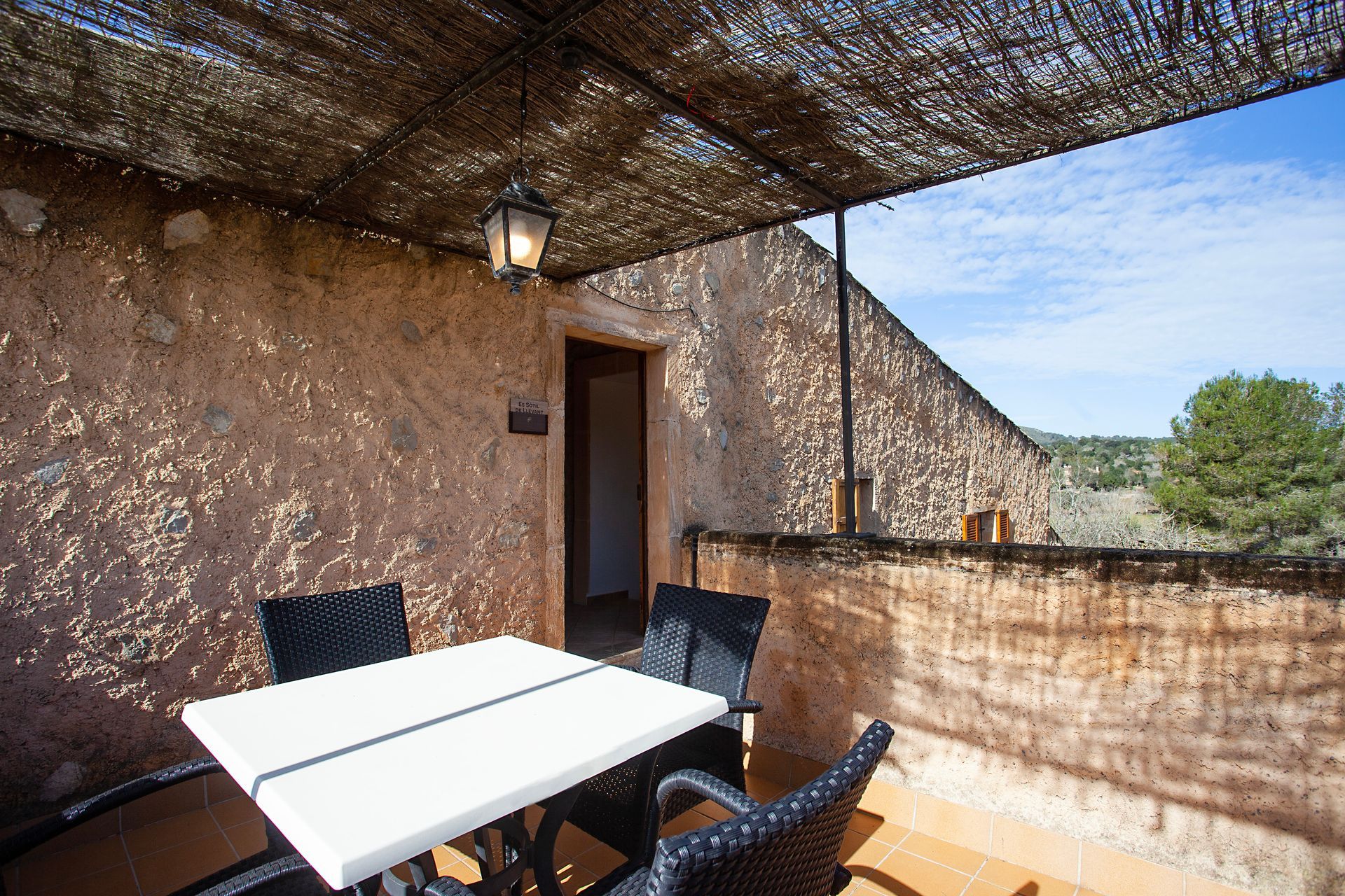 Eine Terrasse mit Tisch und Stühlen unter einem Baldachin