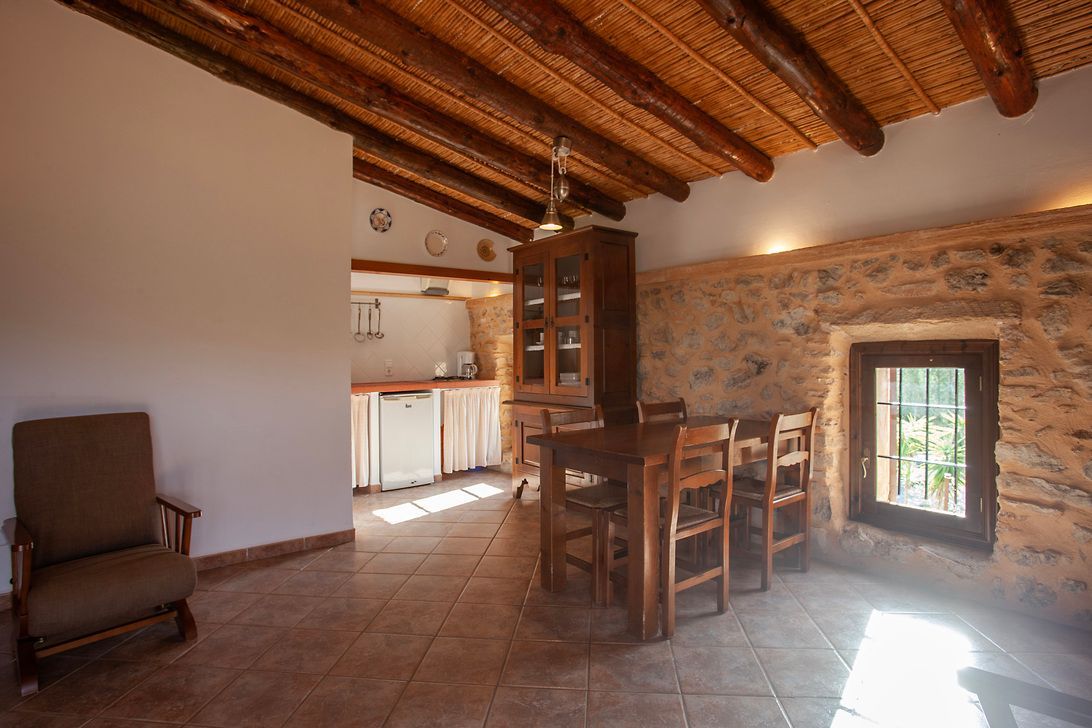 Una sala de estar con una mesa y sillas y una ventana.