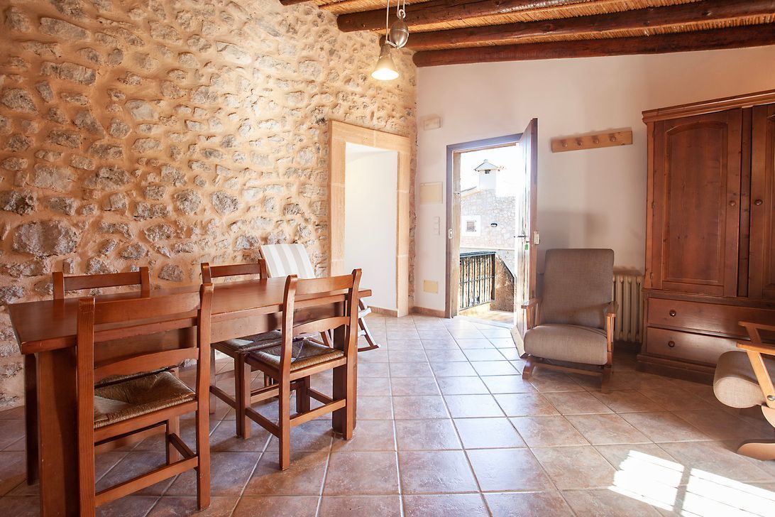 Una sala de estar con una mesa y sillas y una pared de piedra.