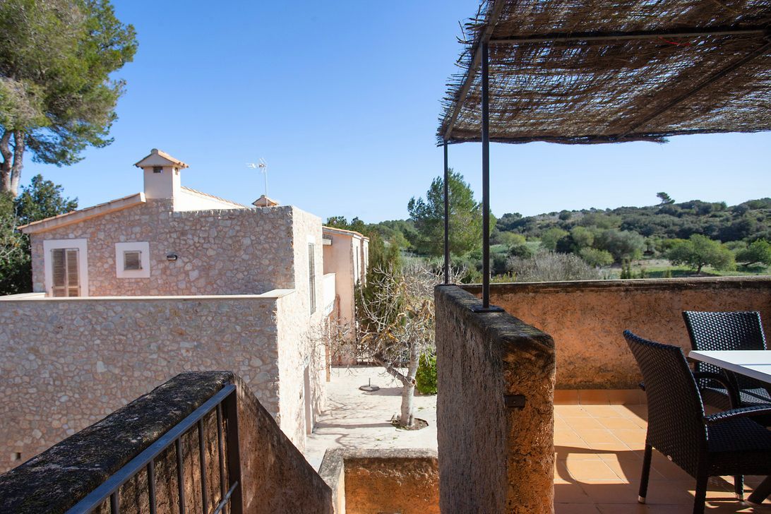 Un balcón con una mesa y sillas y un dosel sobre él.