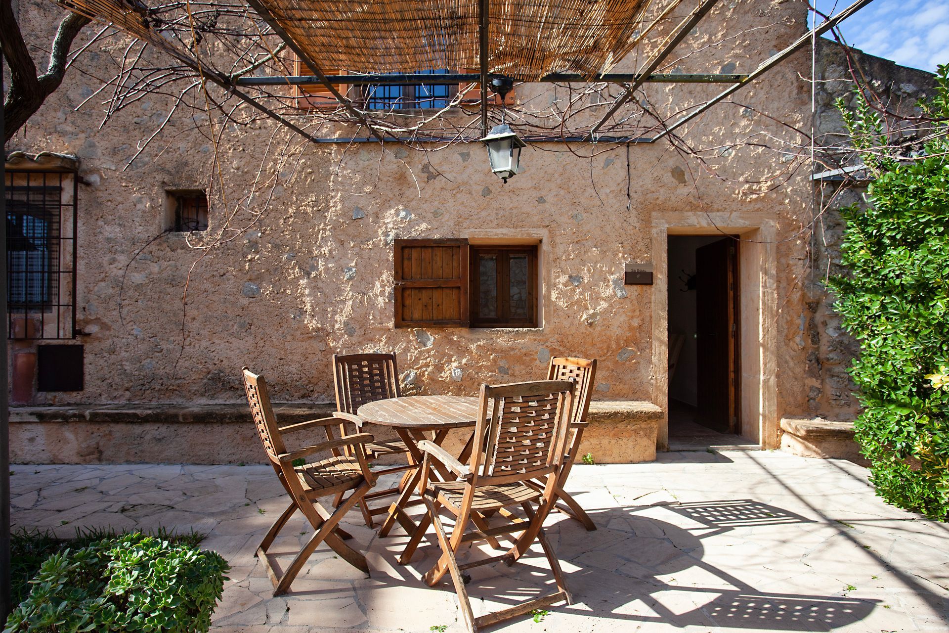 Eine Terrasse mit Tisch und Stühlen unter einem Baldachin