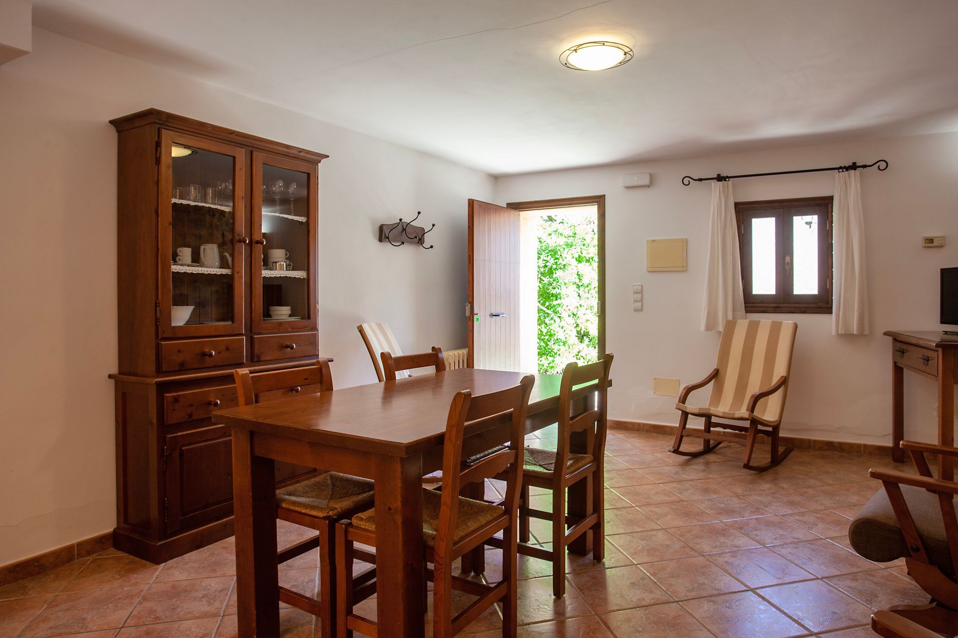 Ein Wohnzimmer mit Tisch und Stühlen und einem Schaukelstuhl