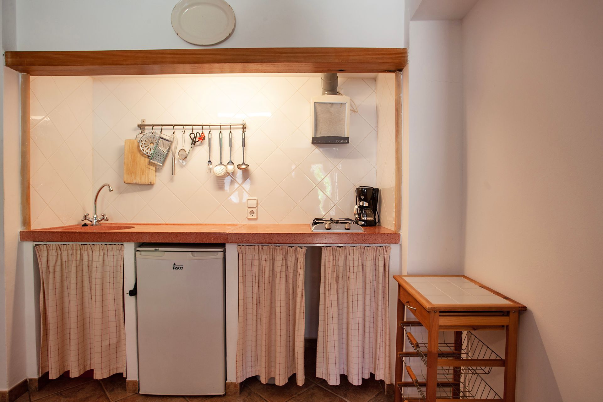 Eine kleine Küche mit Kühlschrank, Spüle und Tisch