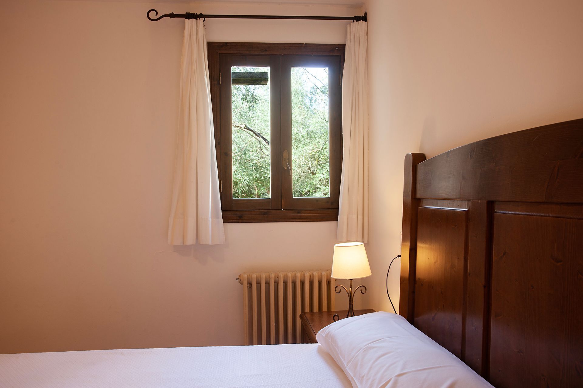 Ein Schlafzimmer mit einem Bett, einer Lampe und einem Fenster