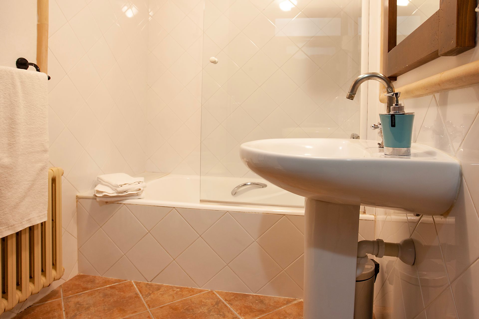 Un baño con lavabo, bañera y espejo.