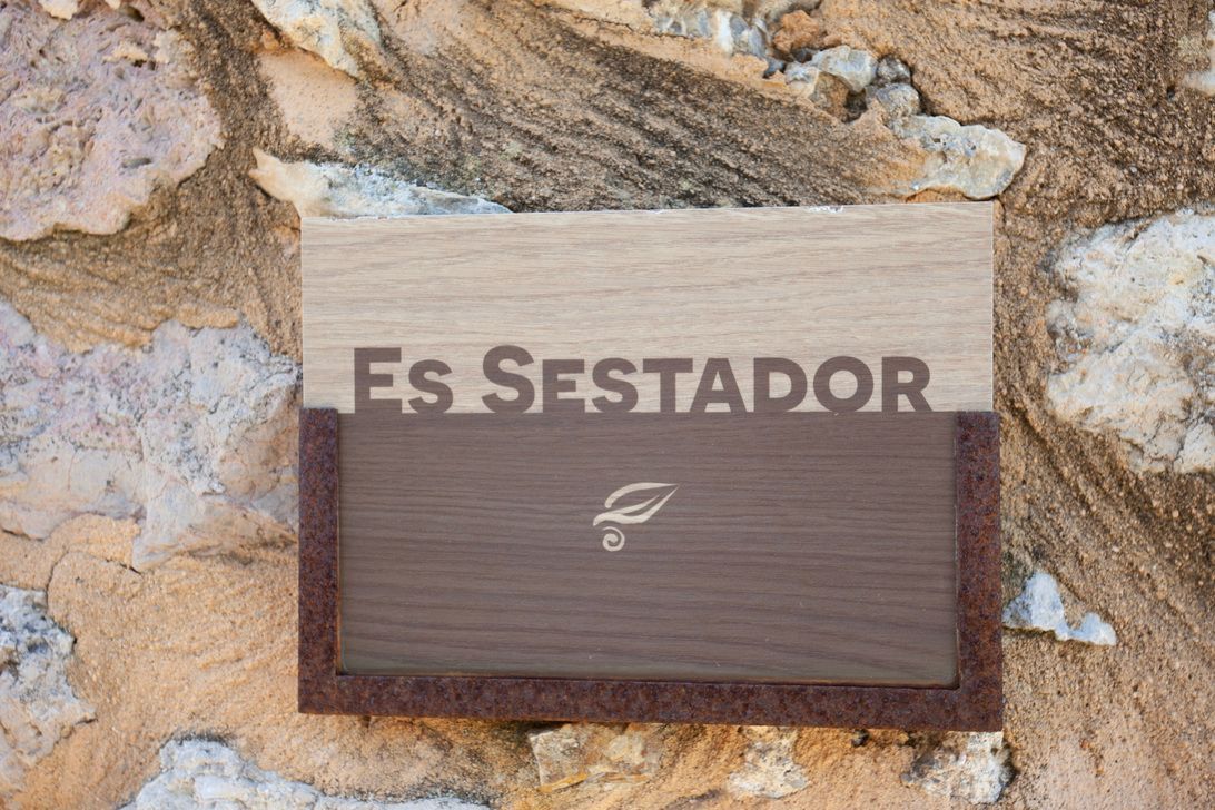 Un cartel de madera en una pared de piedra dice es sestador
