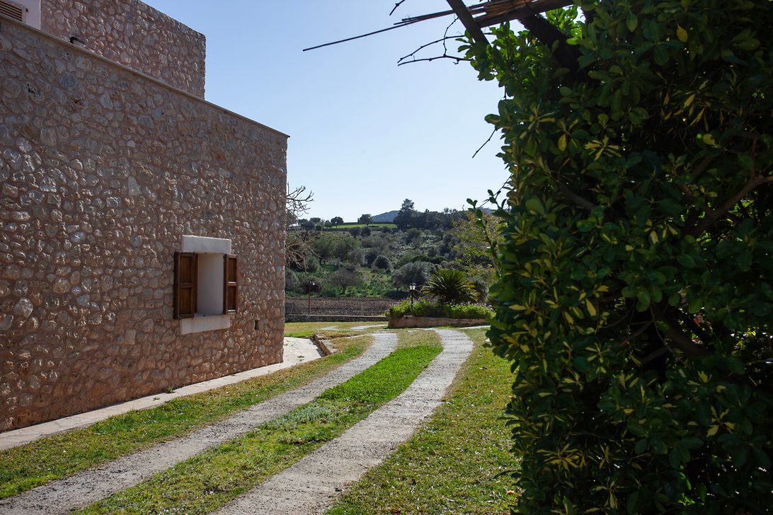Un edificio de piedra con un camino de entrada que conduce a él.