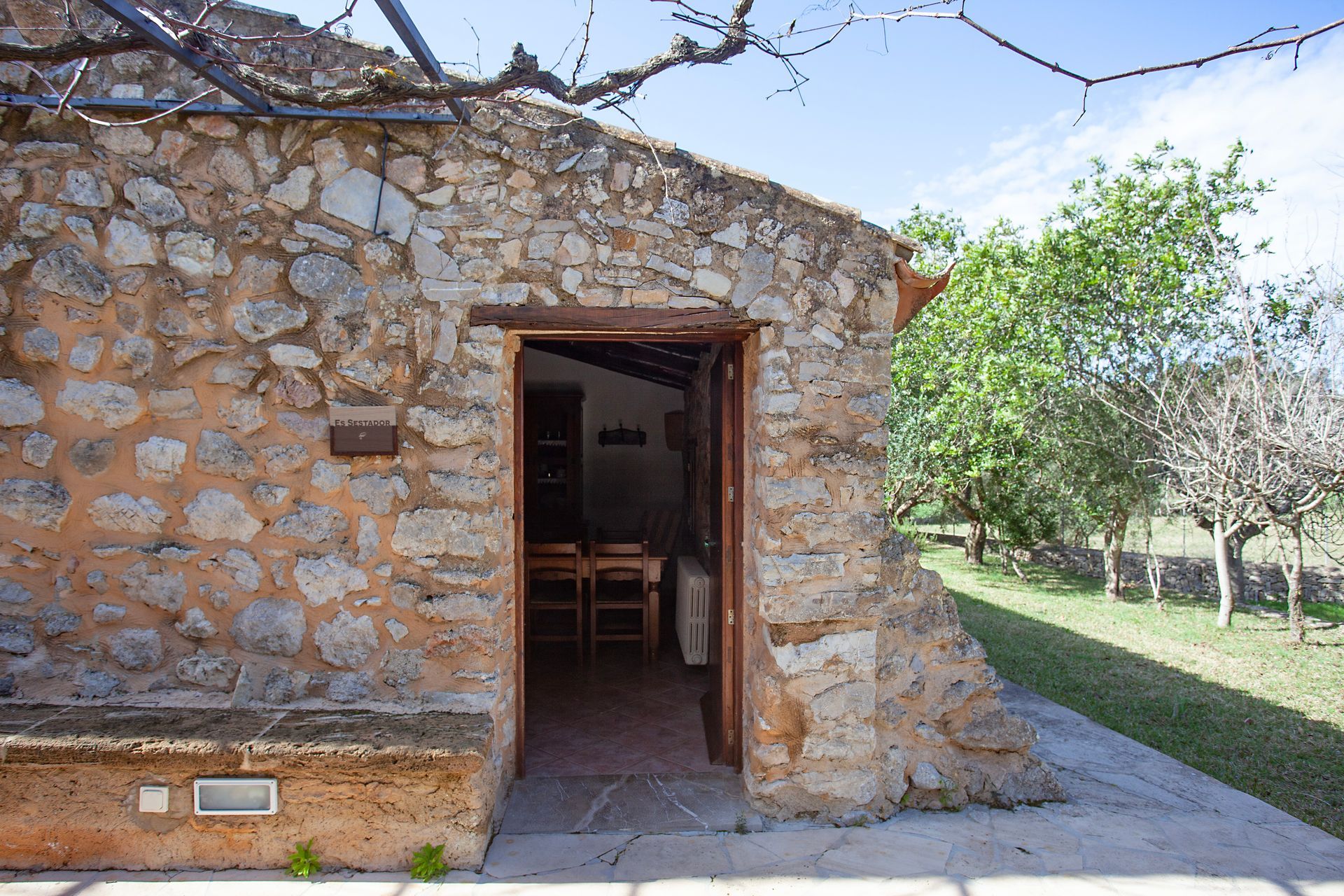 Ein Steingebäude mit einer Holztür und einem Tisch und Stühlen darin