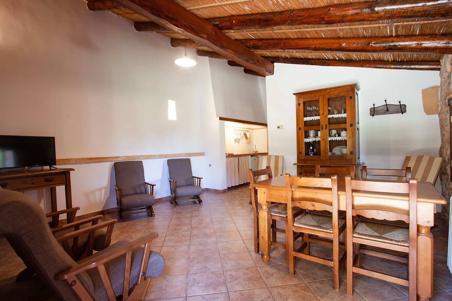 Una sala de estar con una mesa y sillas y un televisor.