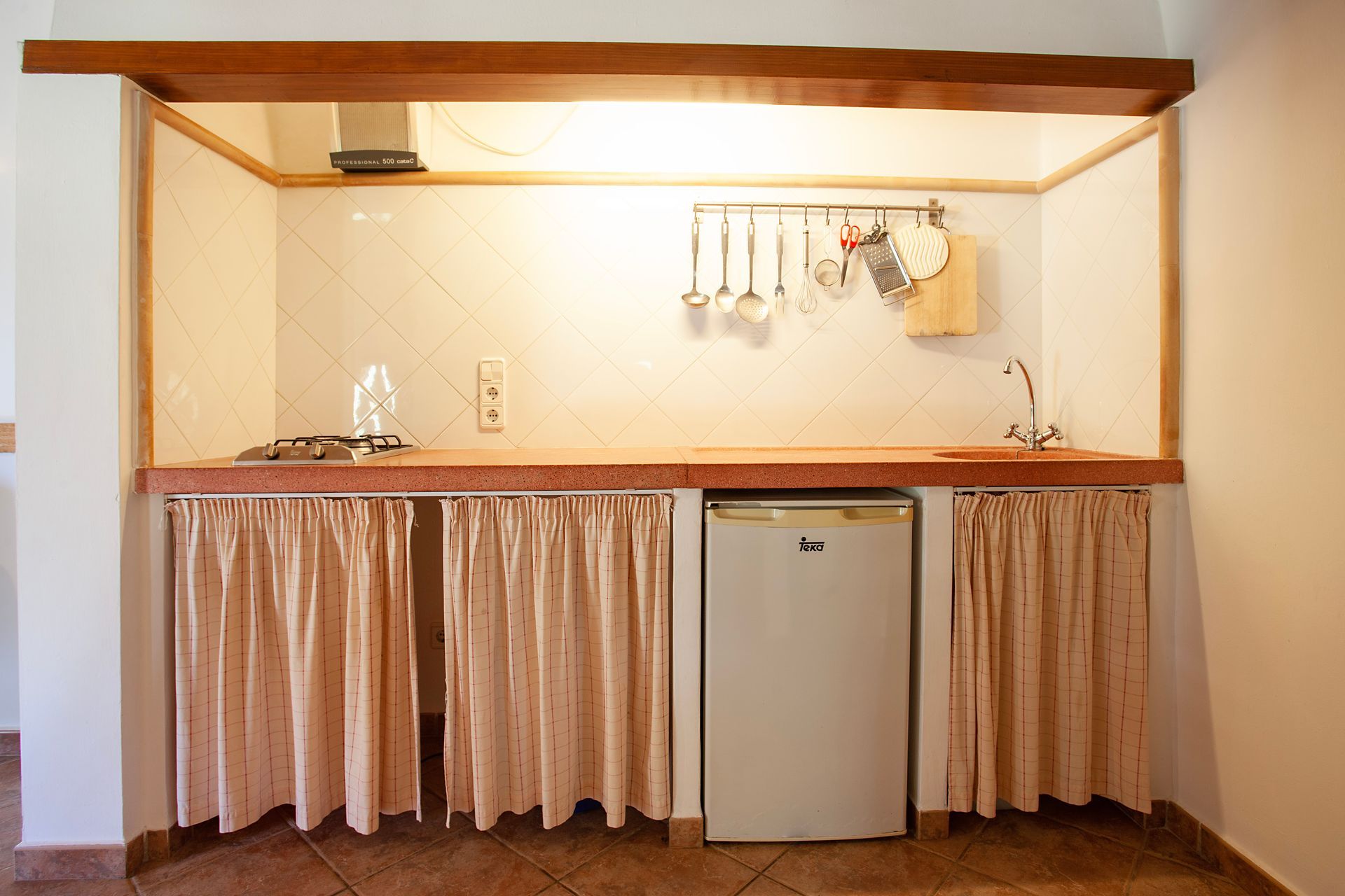 Una cocina con estufa, fregadero y refrigerador.