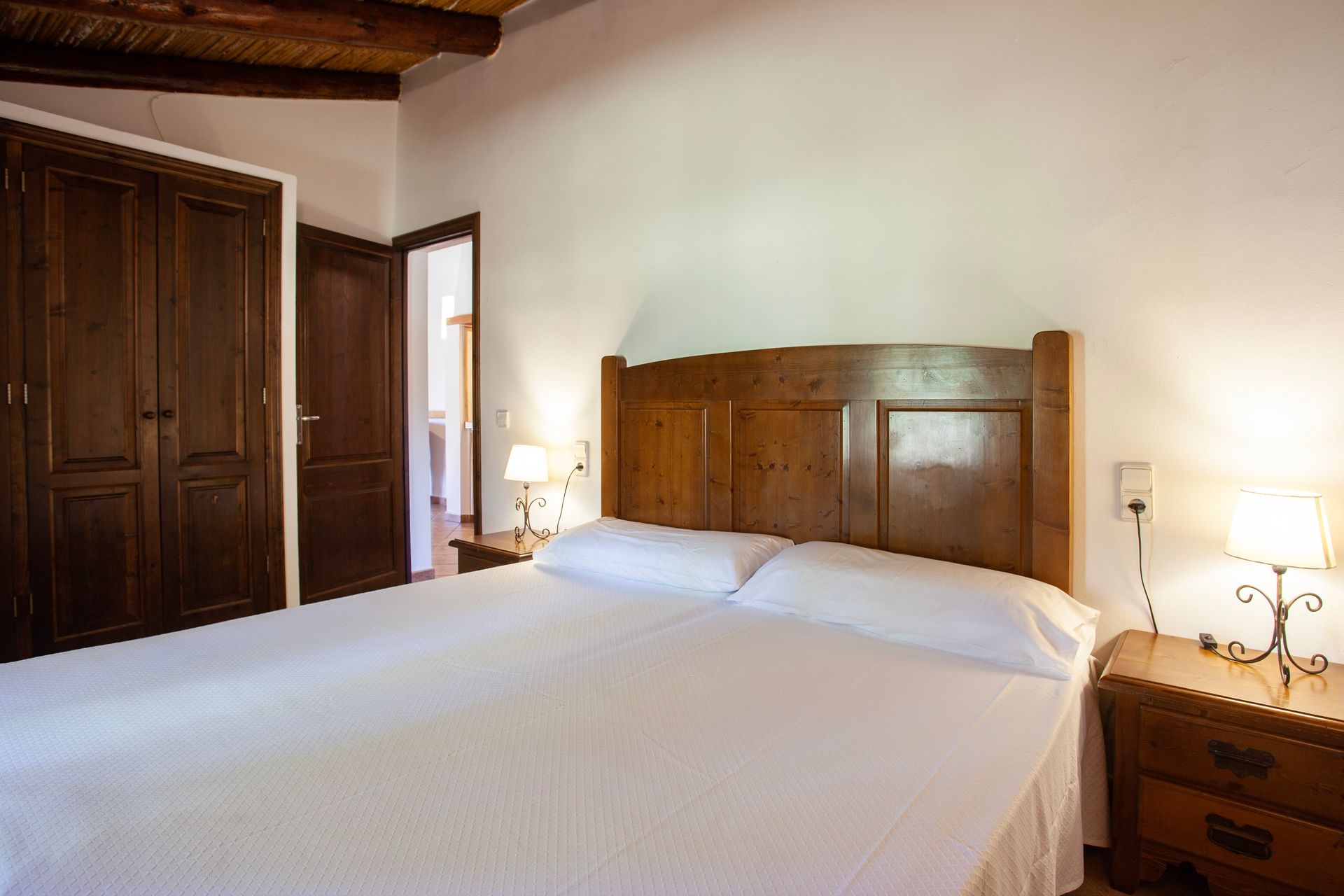 Un dormitorio con una cama grande y un cabecero de madera.