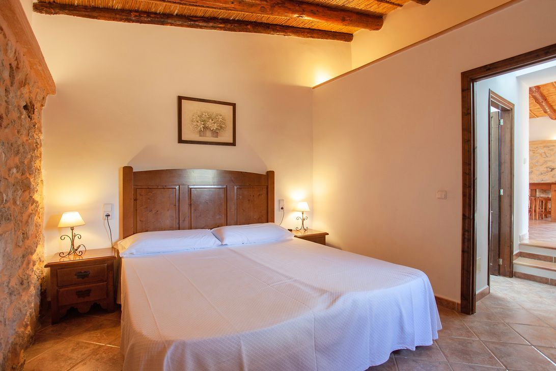 Un dormitorio con una cama grande y dos mesitas de noche.