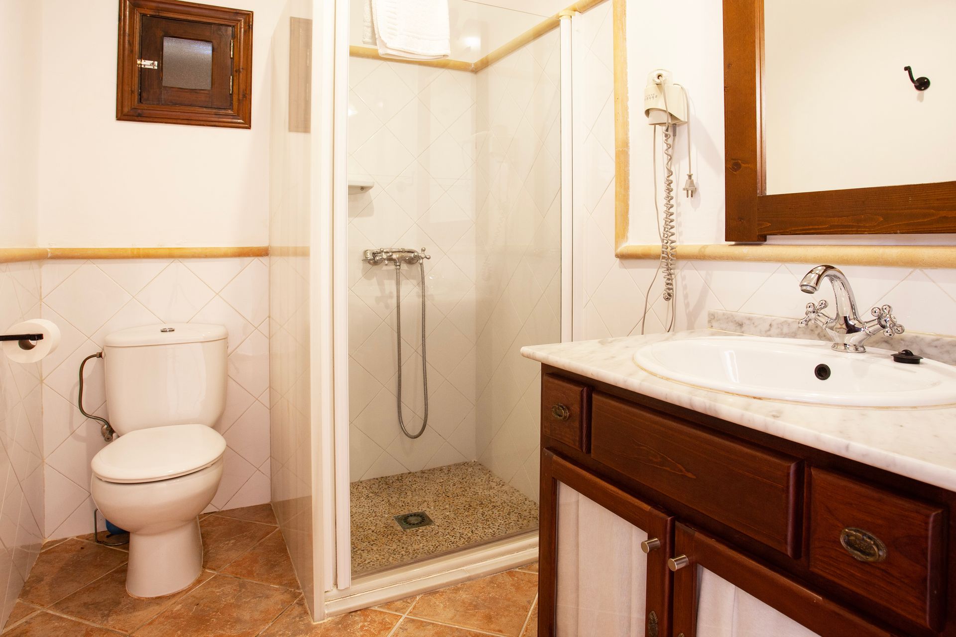 Un baño con inodoro, lavabo y ducha.