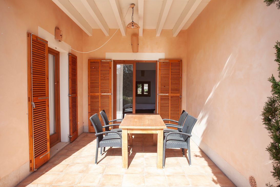 Un patio con una mesa y sillas.