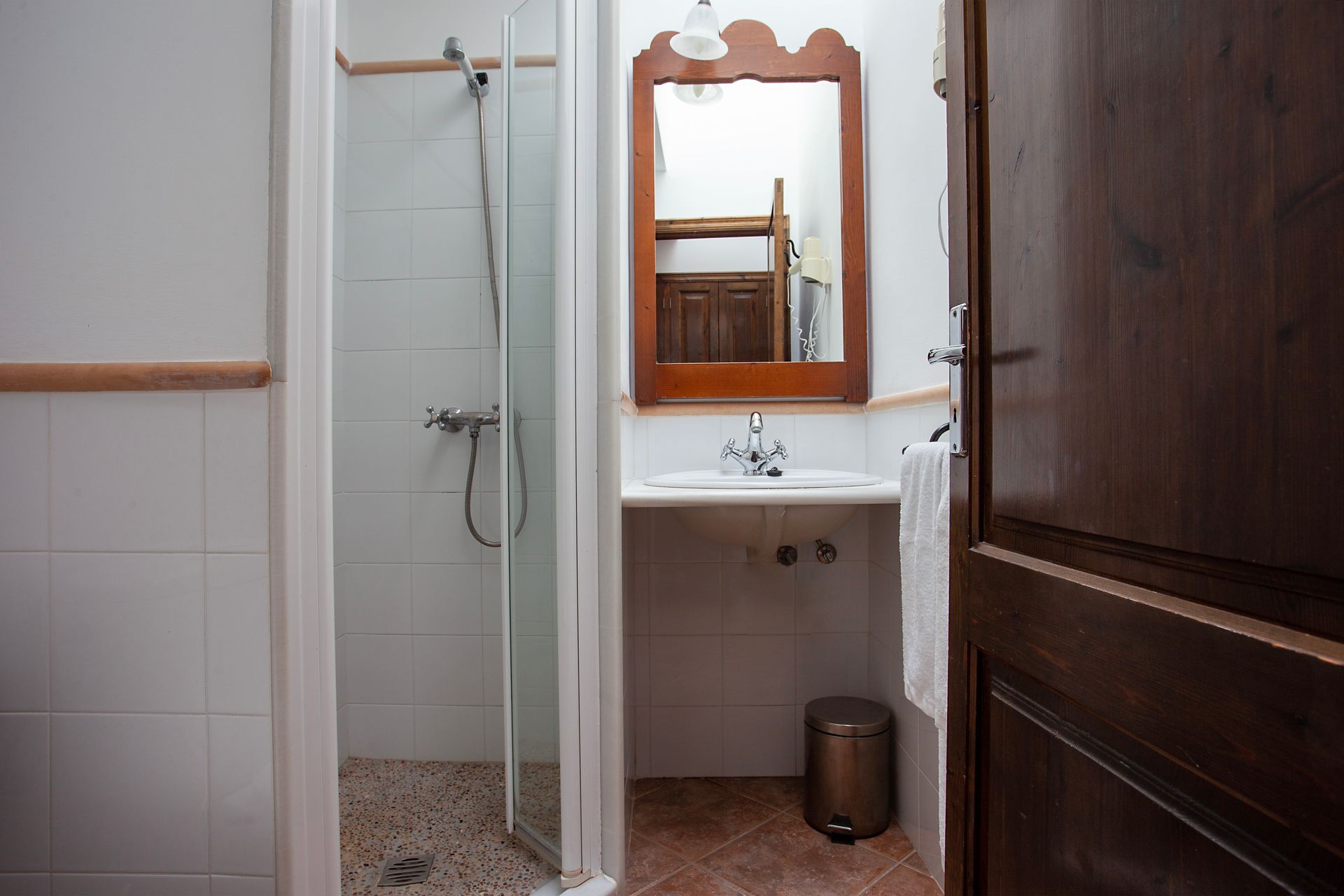 Un baño con lavabo, espejo y ducha.