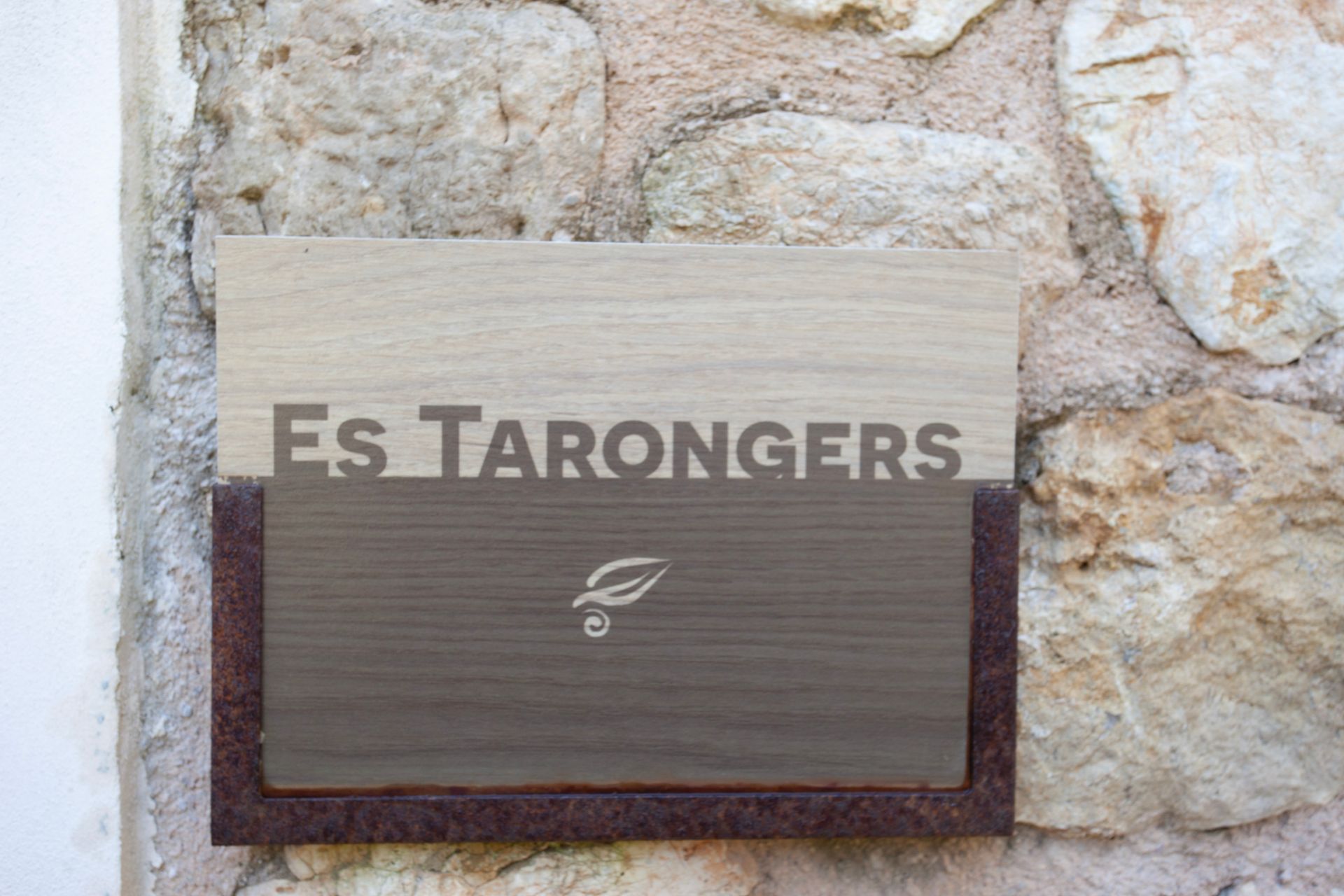 Ein Schild an einer Steinmauer mit der Aufschrift „Es Tarongers“
