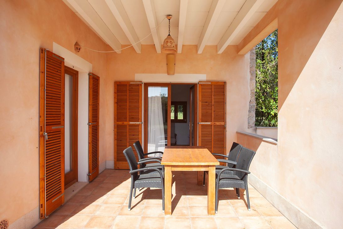 Un patio con una mesa y sillas.