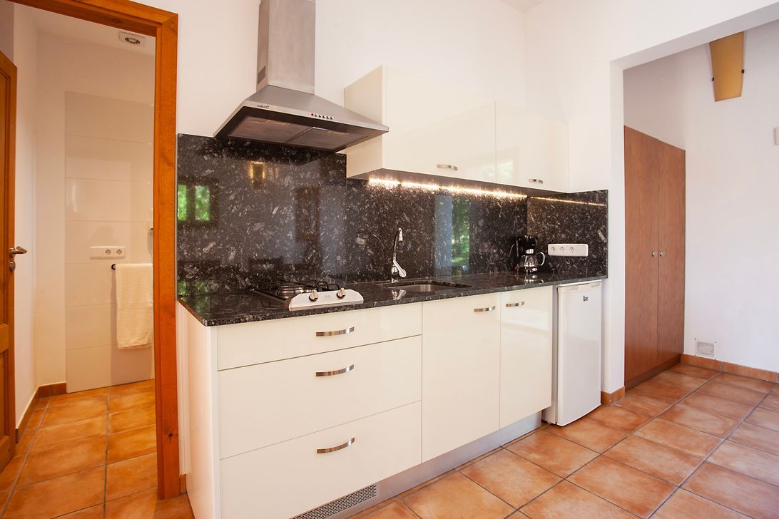 Una cocina con gabinetes blancos y un horno de estufa.