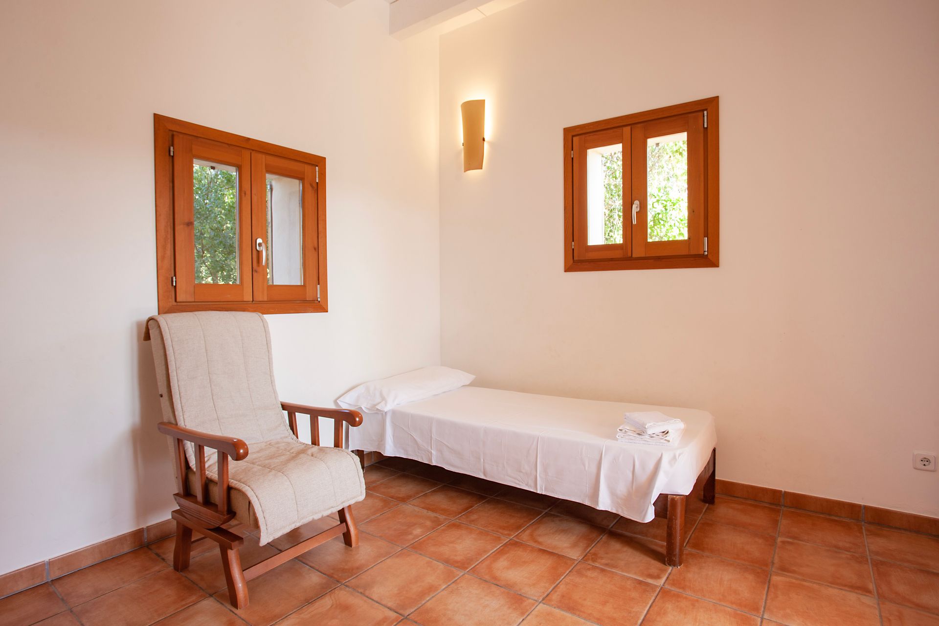 Ein Schlafzimmer mit einem Einzelbett und einem Sessel