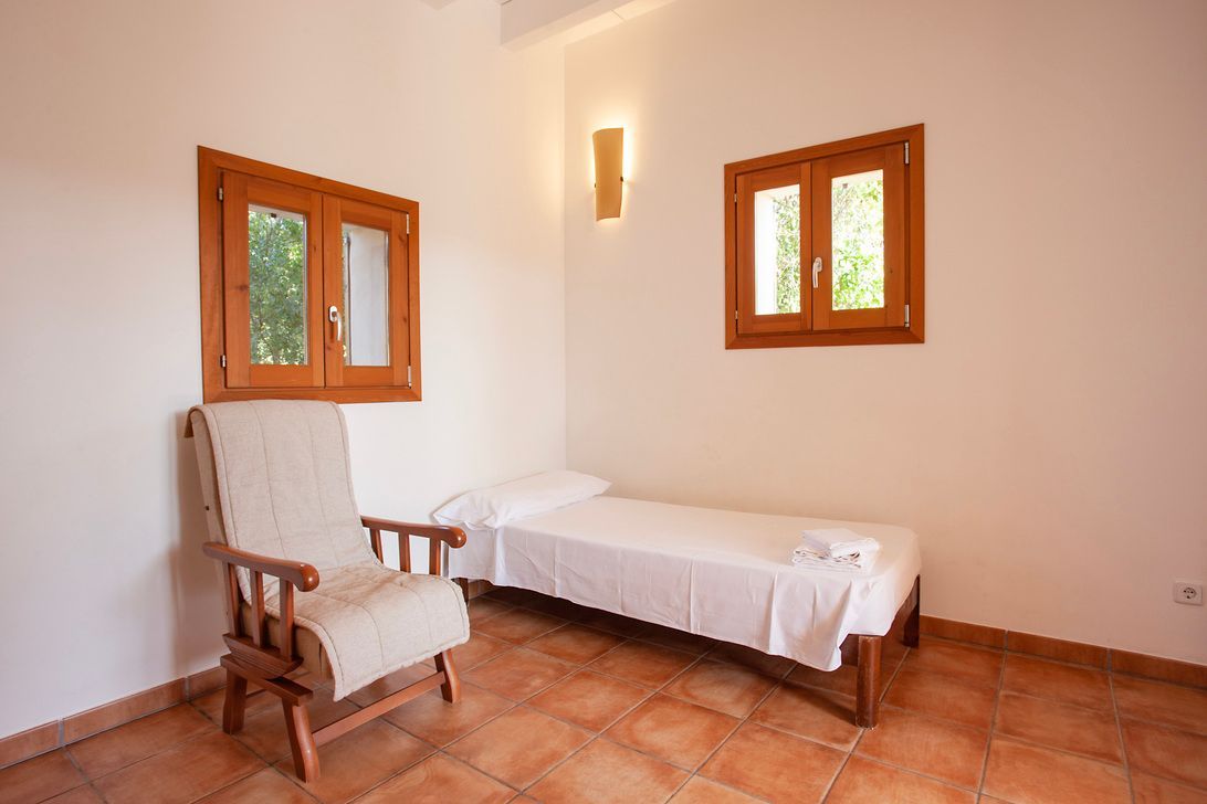 Hay una silla y una cama en la habitación.