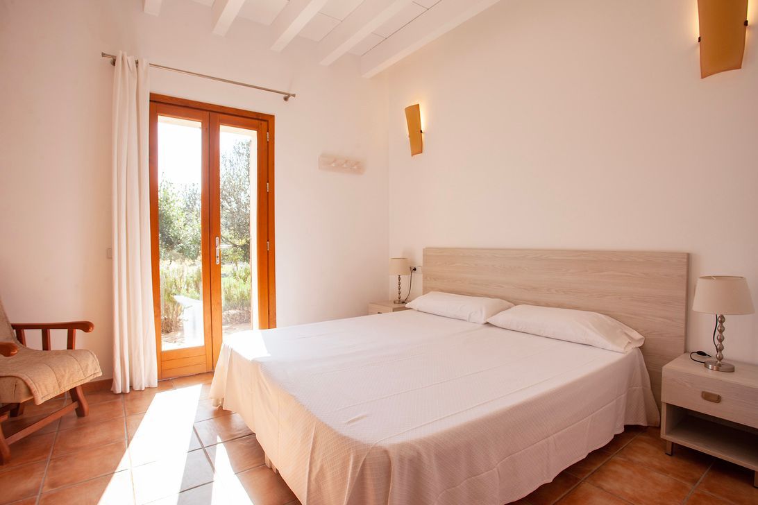 Un dormitorio con una cama grande y una silla.