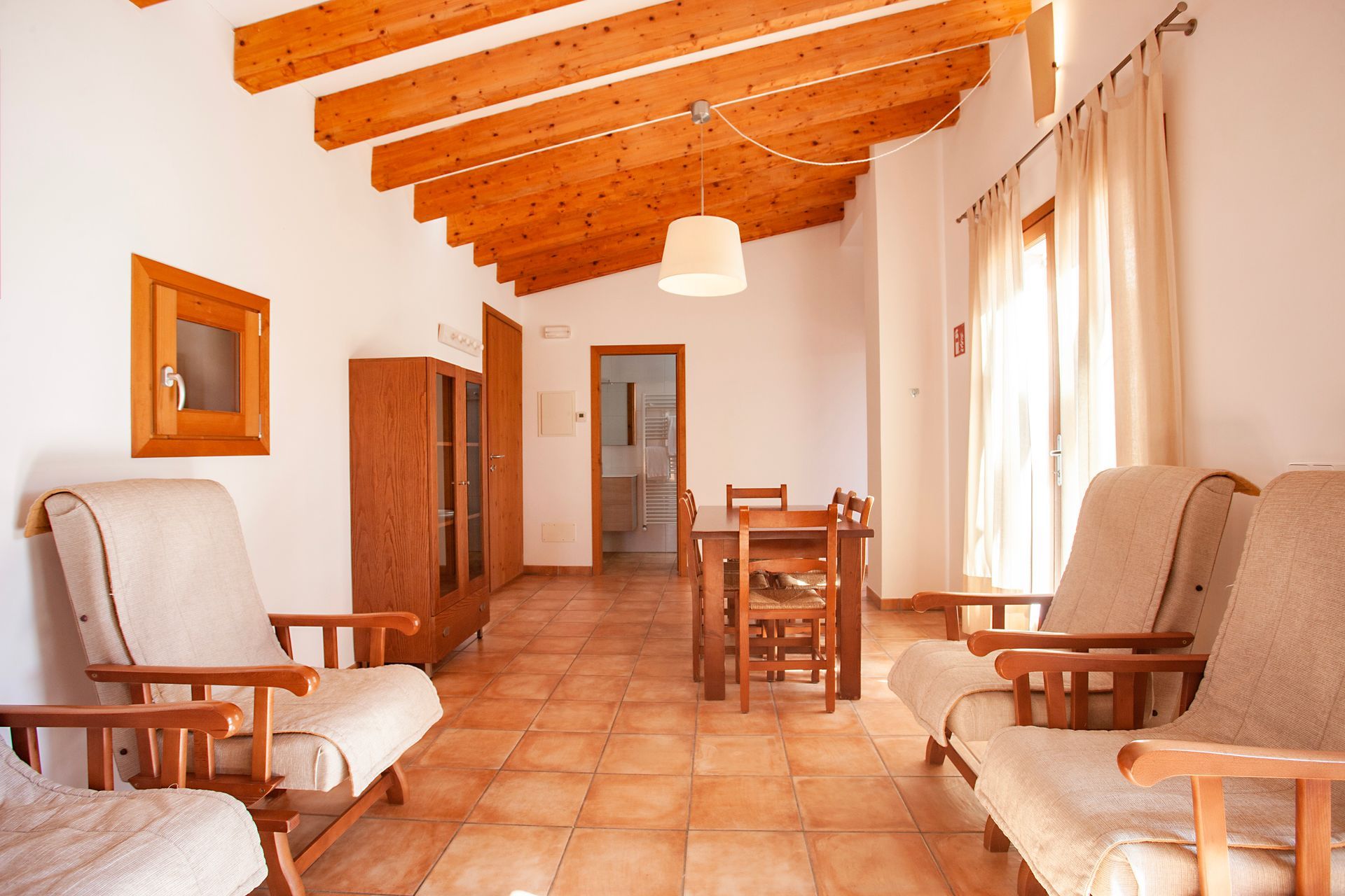 Ein Wohnzimmer mit Tisch und Stühlen und einer Holzdecke