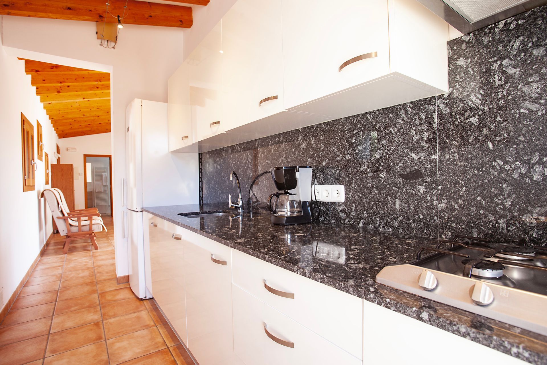 Eine Küche mit Granitarbeitsplatten und weißen Schränken