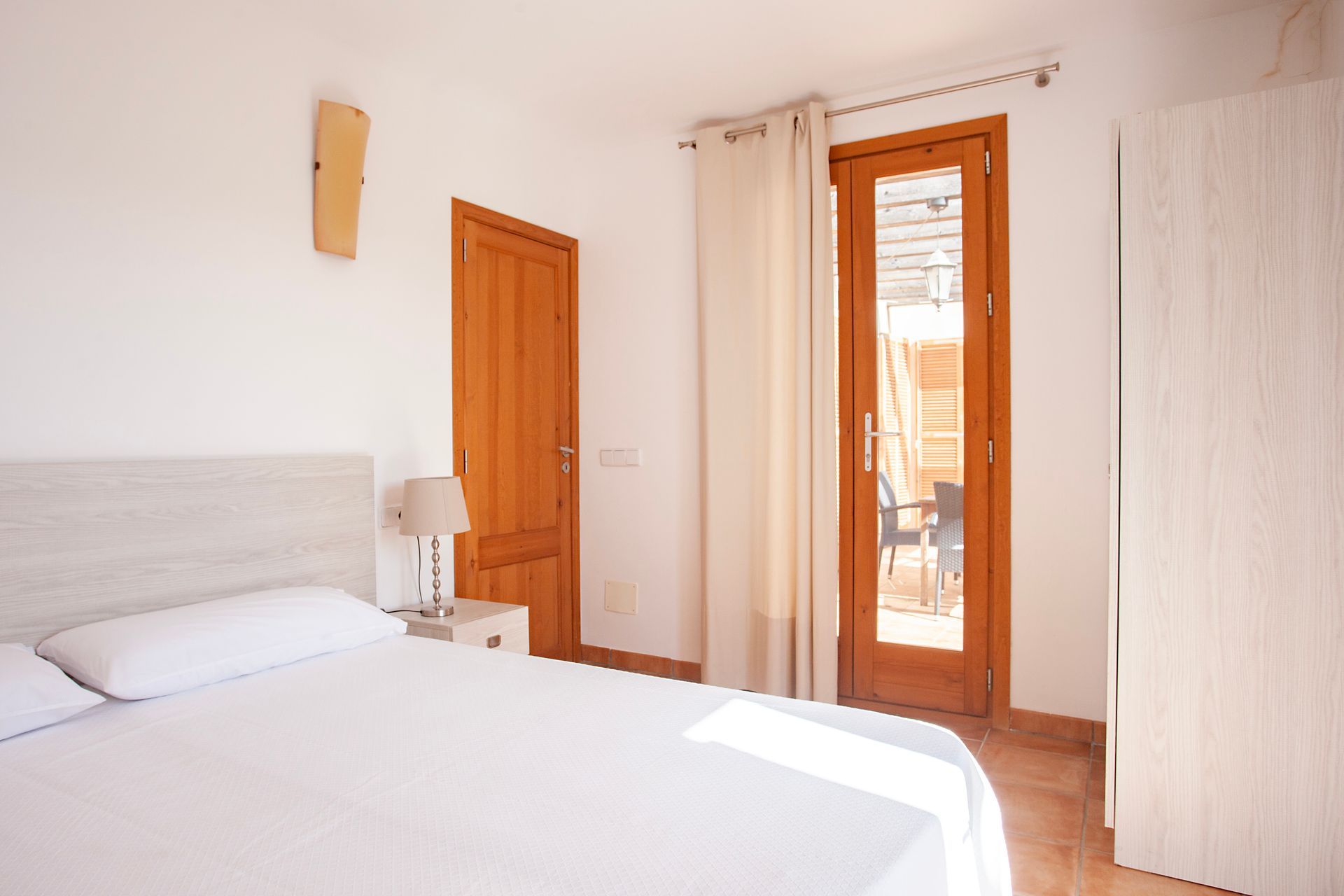 Ein Schlafzimmer mit einem Kingsize-Bett und einer Holztür