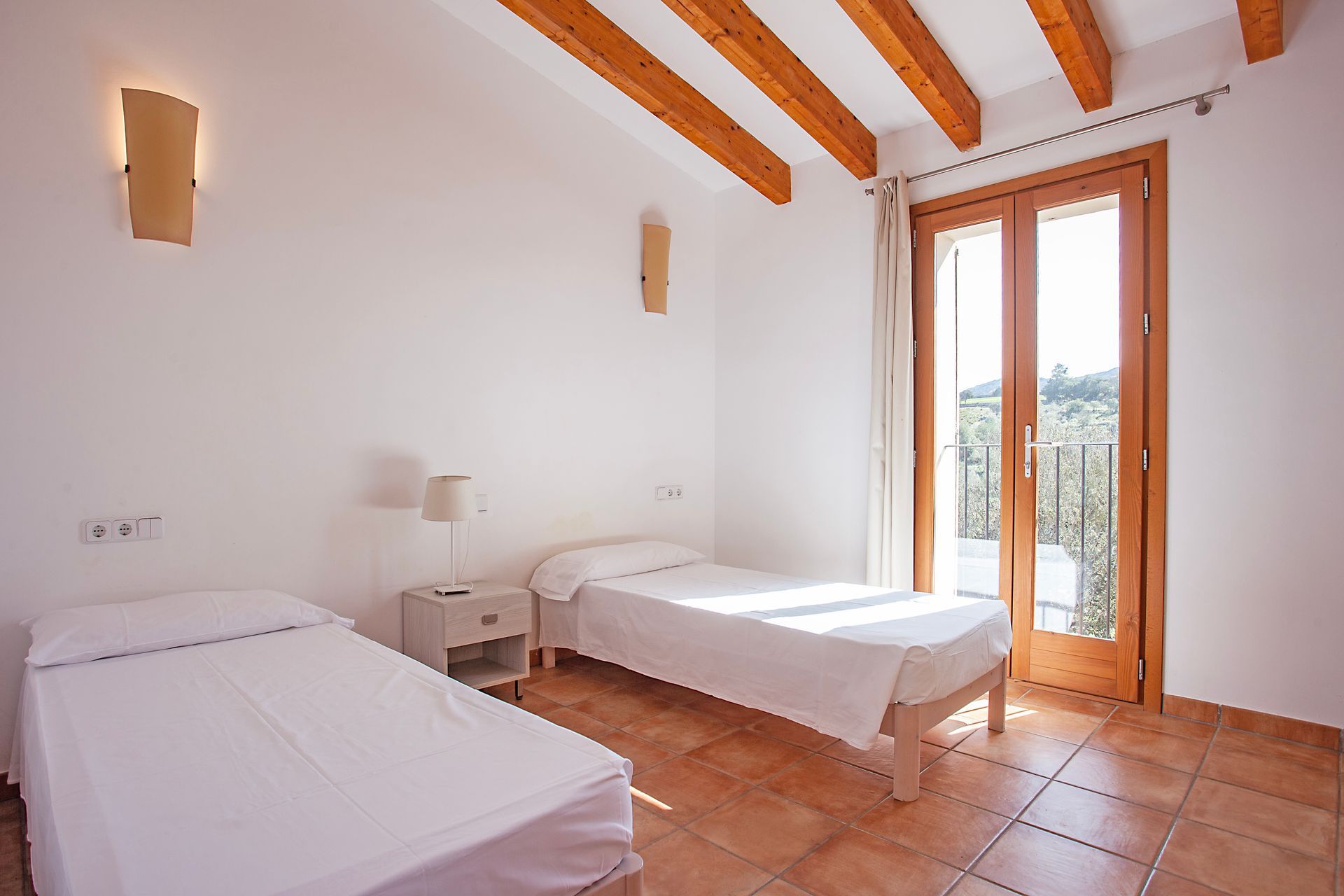 Ein Schlafzimmer mit zwei Betten und einem großen Fenster