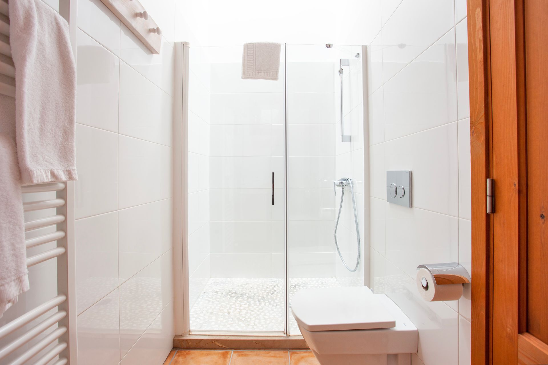 Ein Badezimmer mit Toilette, Waschbecken, Dusche und Glastür.