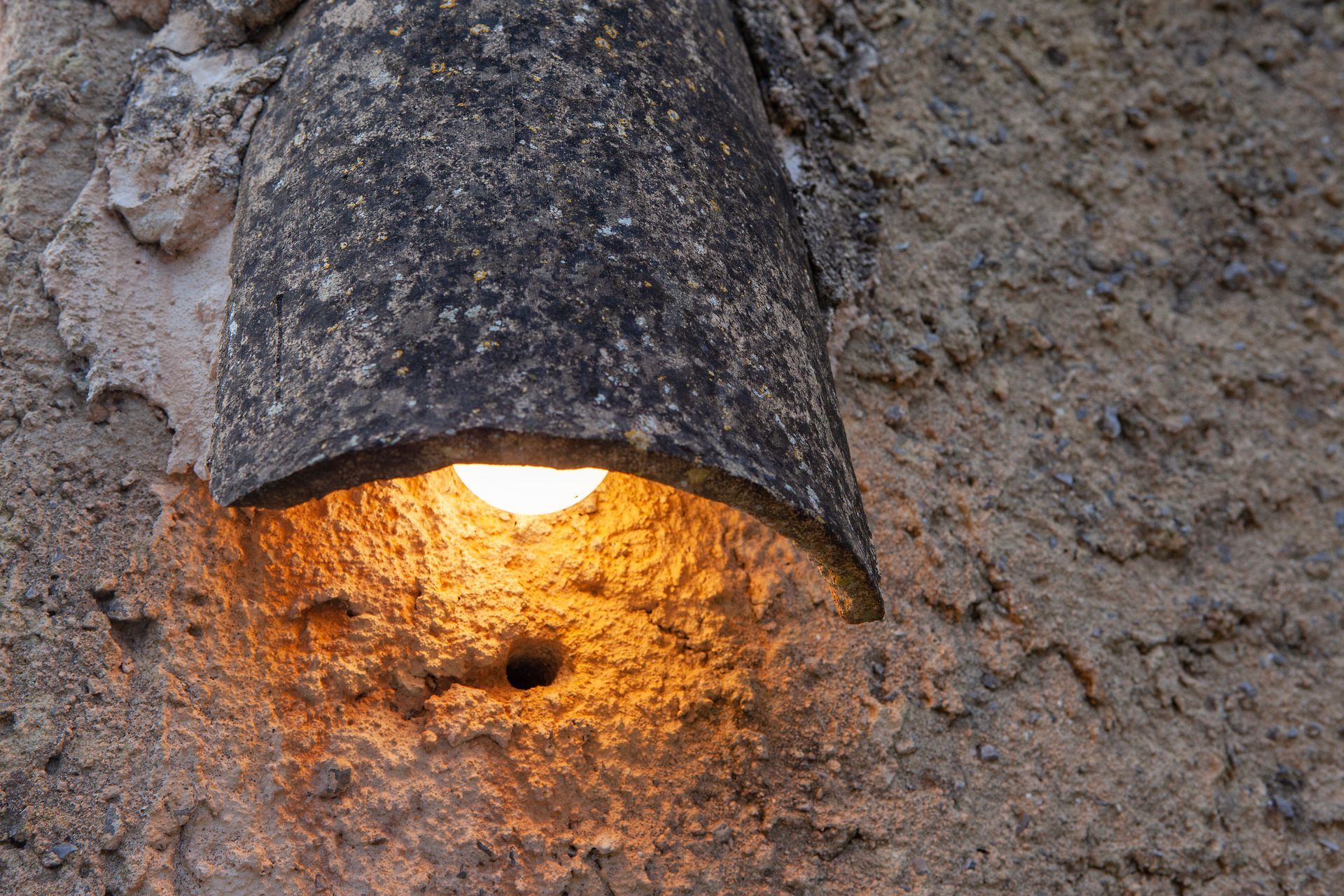 Una luz brilla a través de un agujero en una pared.