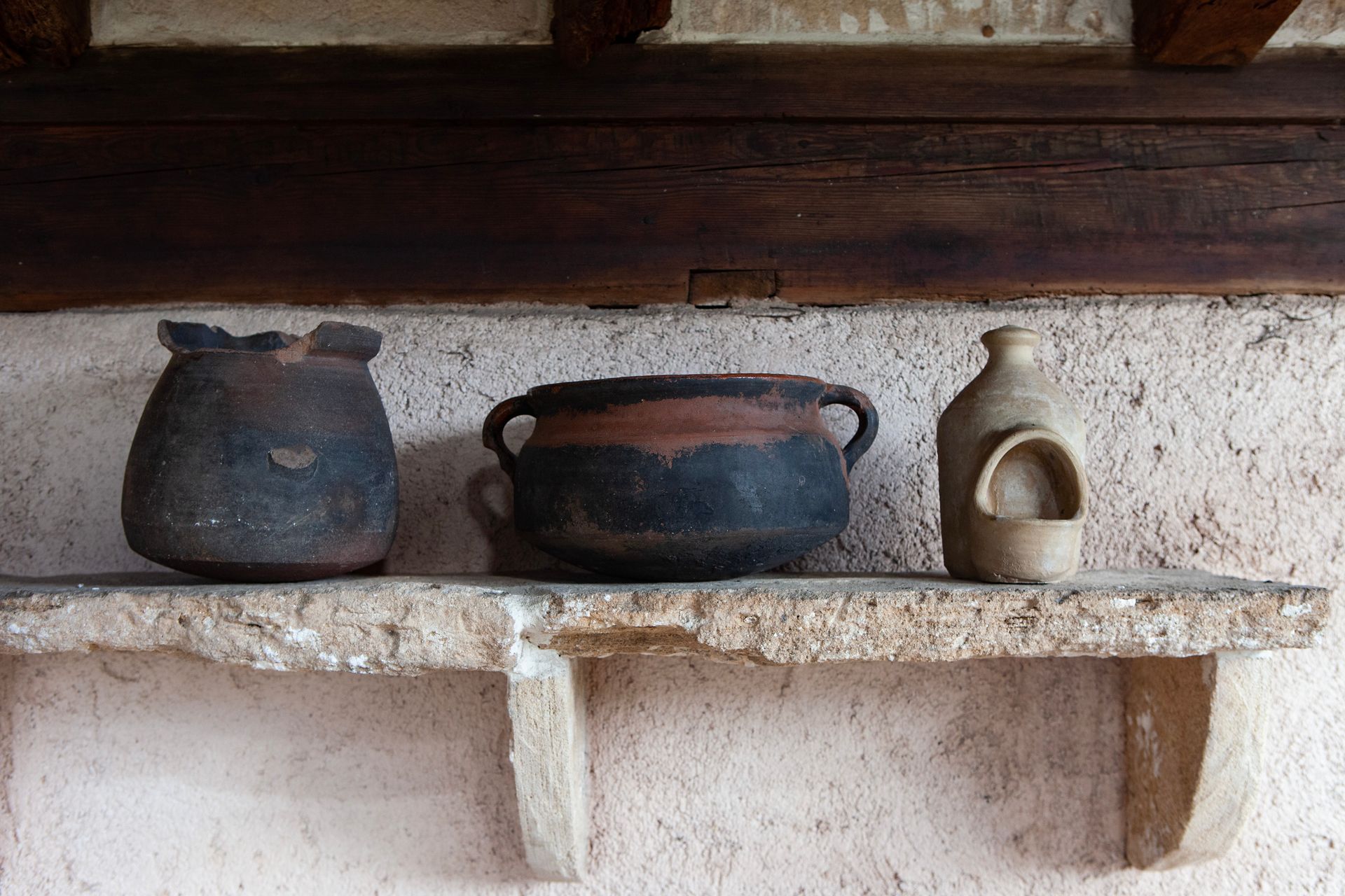 Ein Regal mit drei Töpfen und einer Flasche darauf