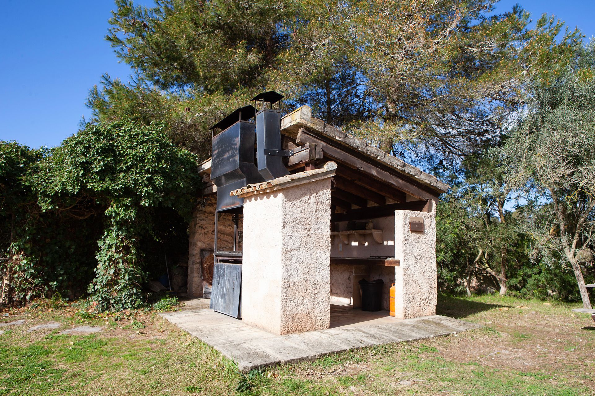 Un pequeño edificio de piedra con una chimenea en la parte superior.