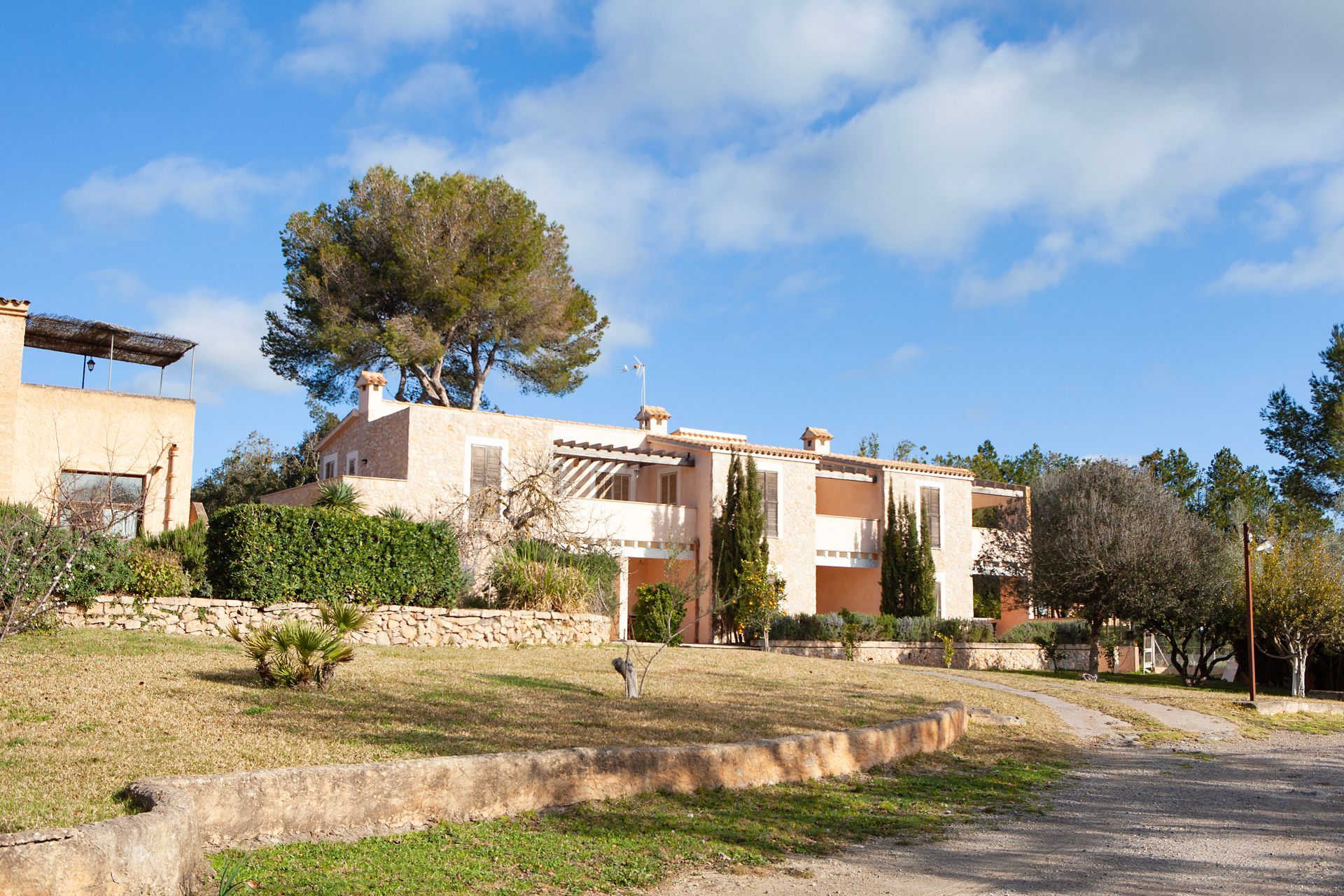 Una casa grande con muchos árboles al frente.