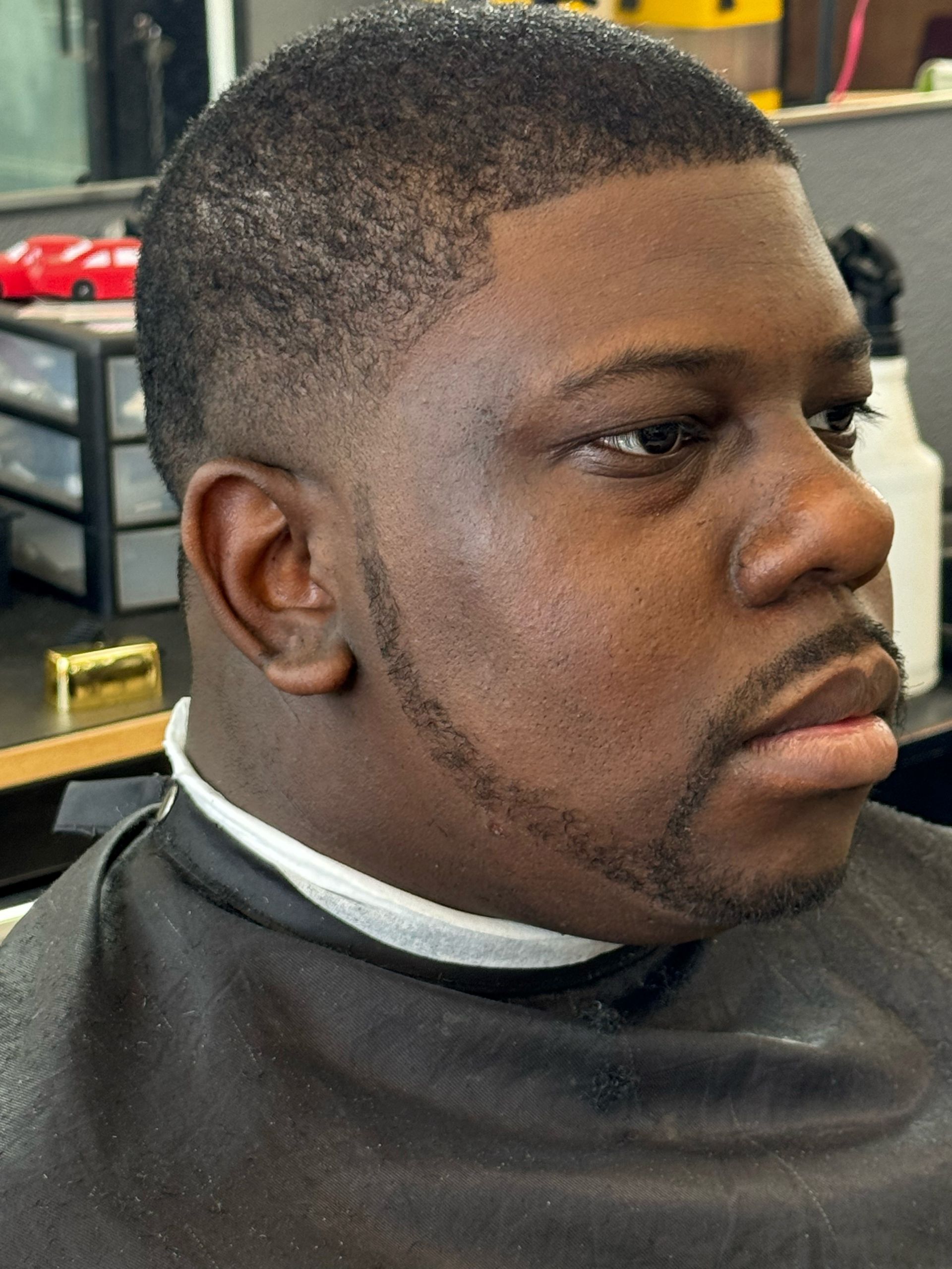 A man with a beard is getting his hair cut at a barber shop