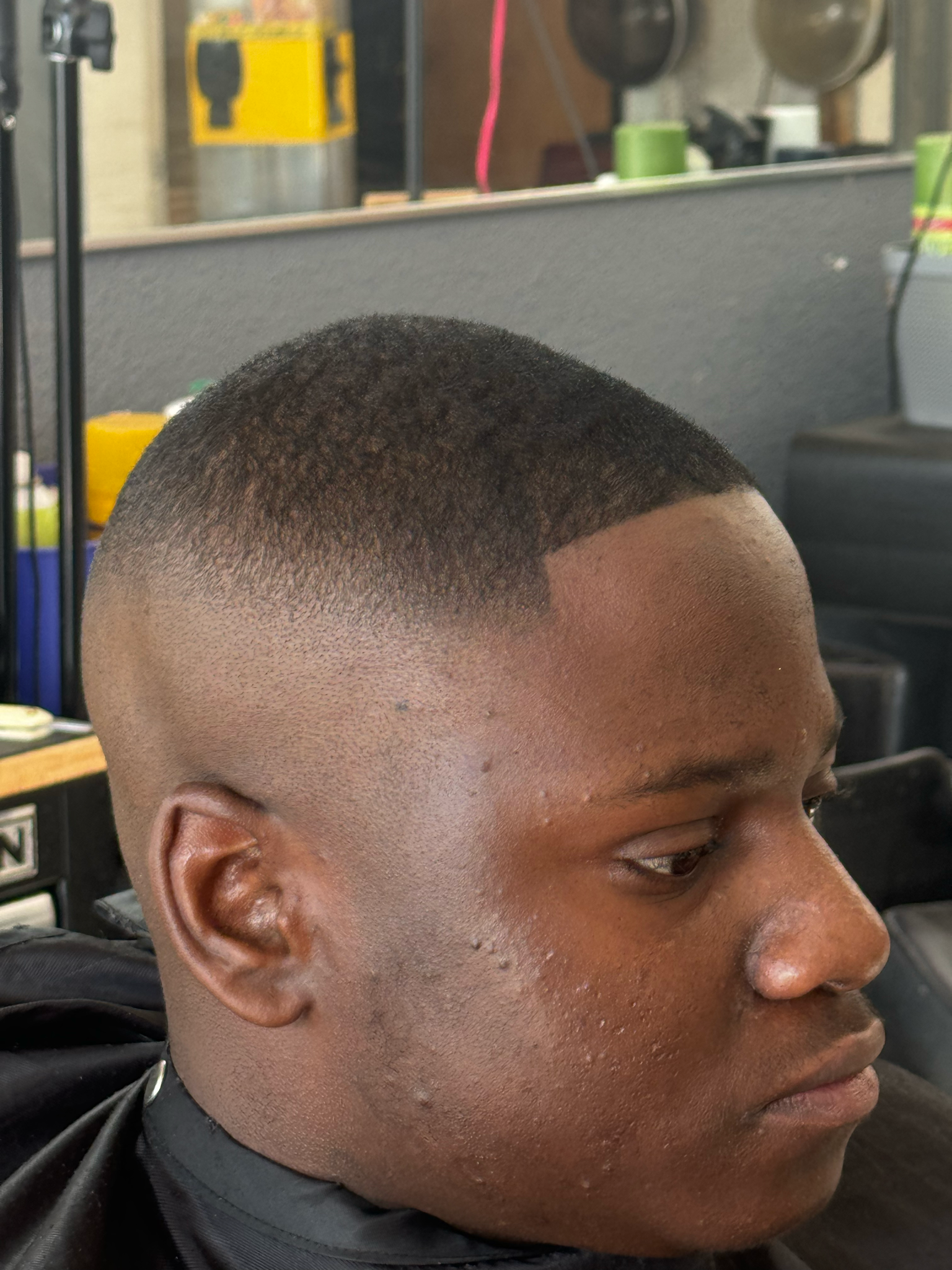 A man is getting his hair cut at a barber shop.