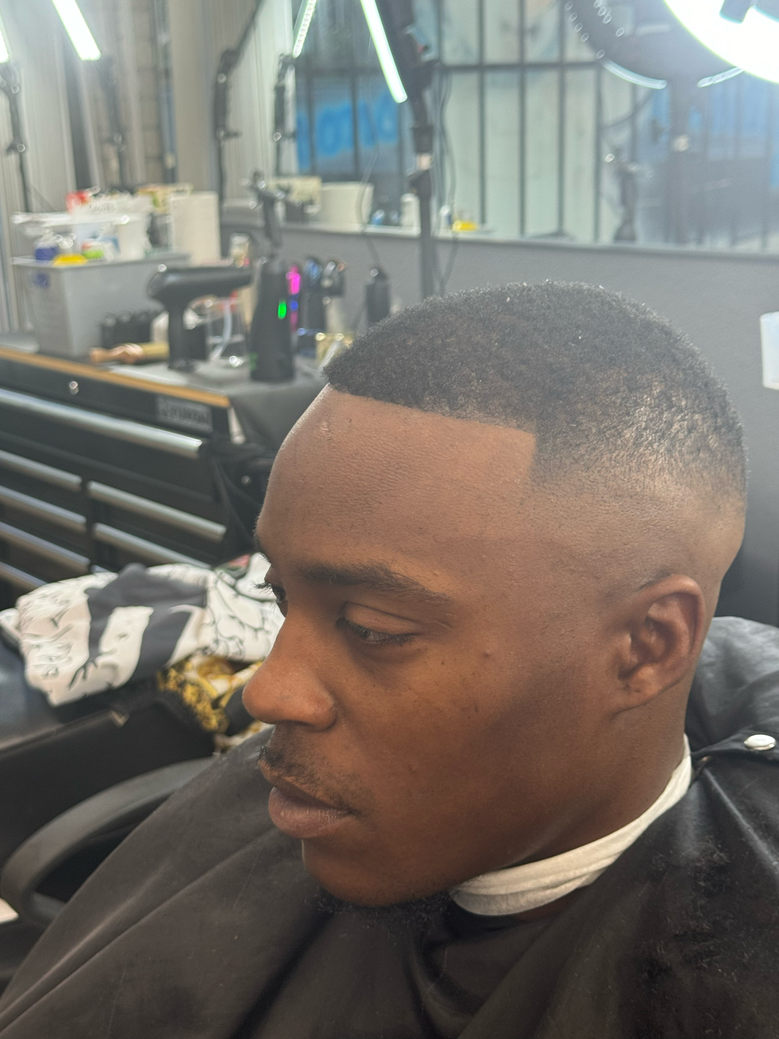 A man is getting his hair cut at a barber shop.