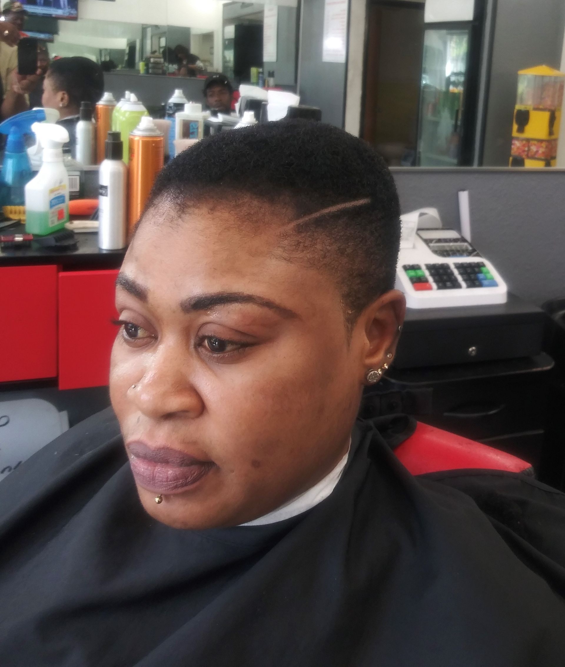 A woman is getting her hair cut at a barber shop