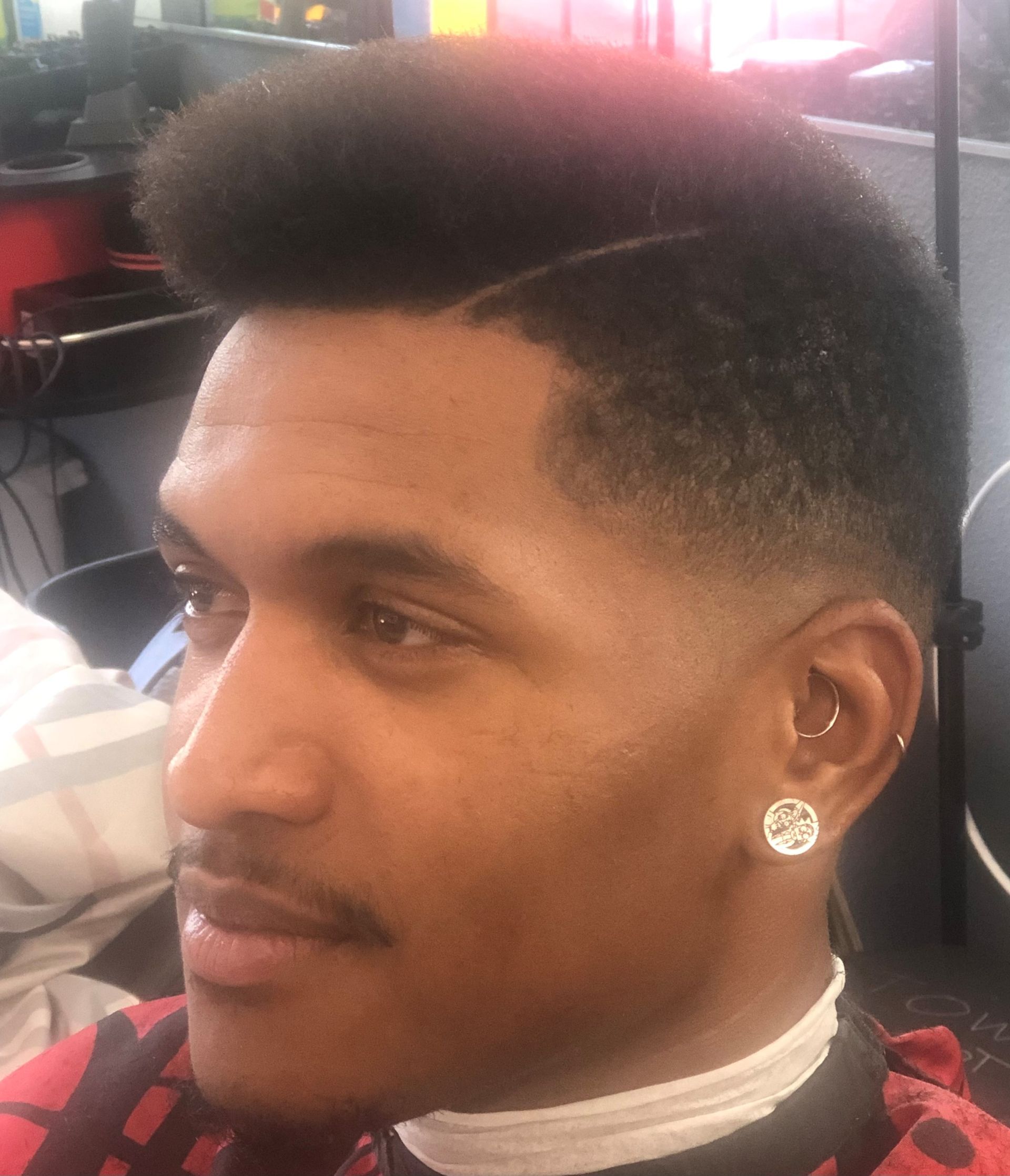 A man is getting his hair cut at a barber shop.