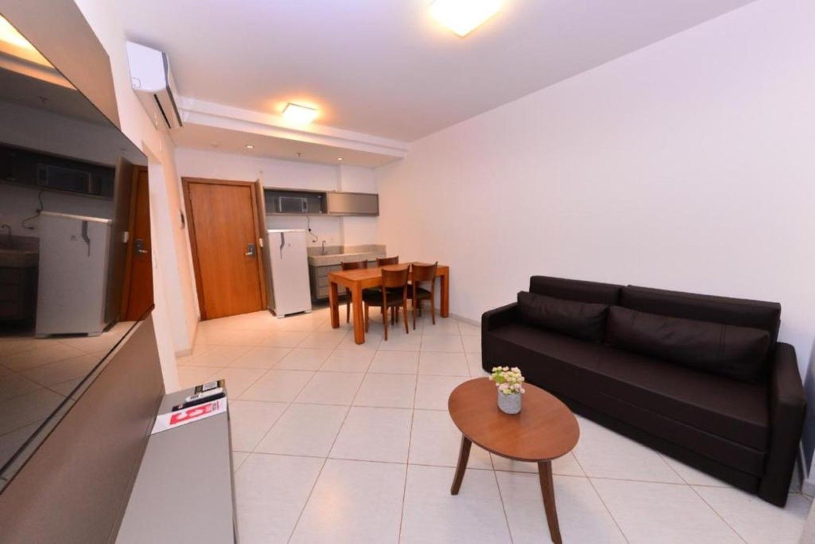 Interior de um pequeno apartamento com cozinha, sala de jantar e sala de estar.