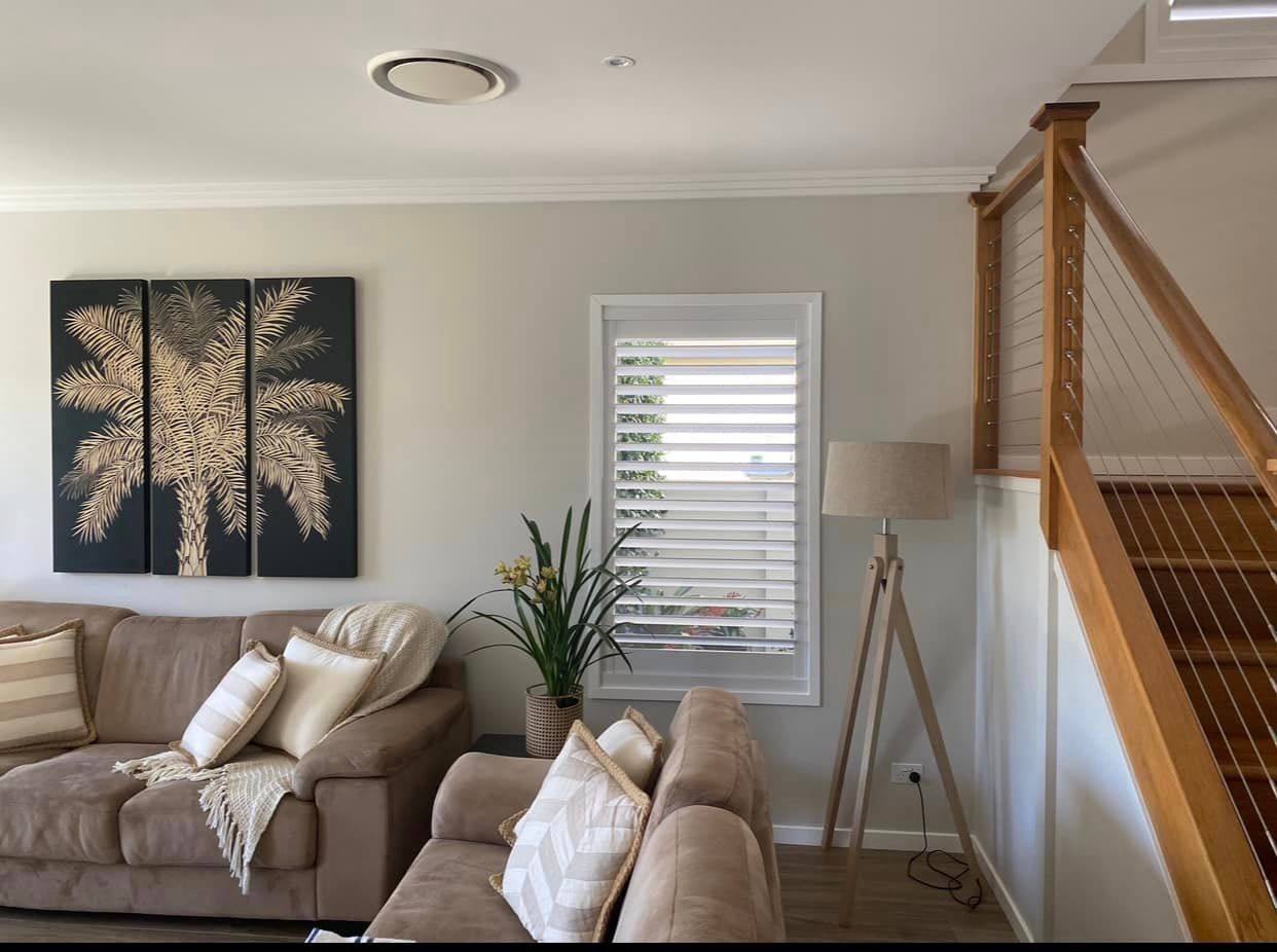 Inviting Living Room Featuring Stylish Couch, Illuminating Lamp, and Stairs— Window Coverings in Gold Coast, QLD
