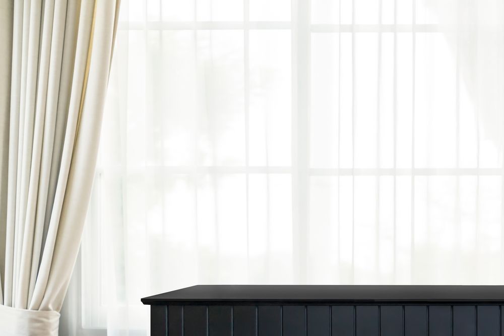 A Table In Front Of A Window With White Curtains — Curtains in Gold Coast, QLD