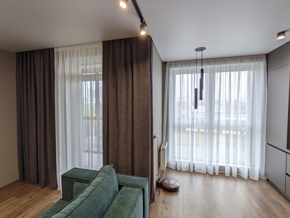 A Living Room With A Green Couch And White Curtains — Window Coverings in Gold Coast, QLD