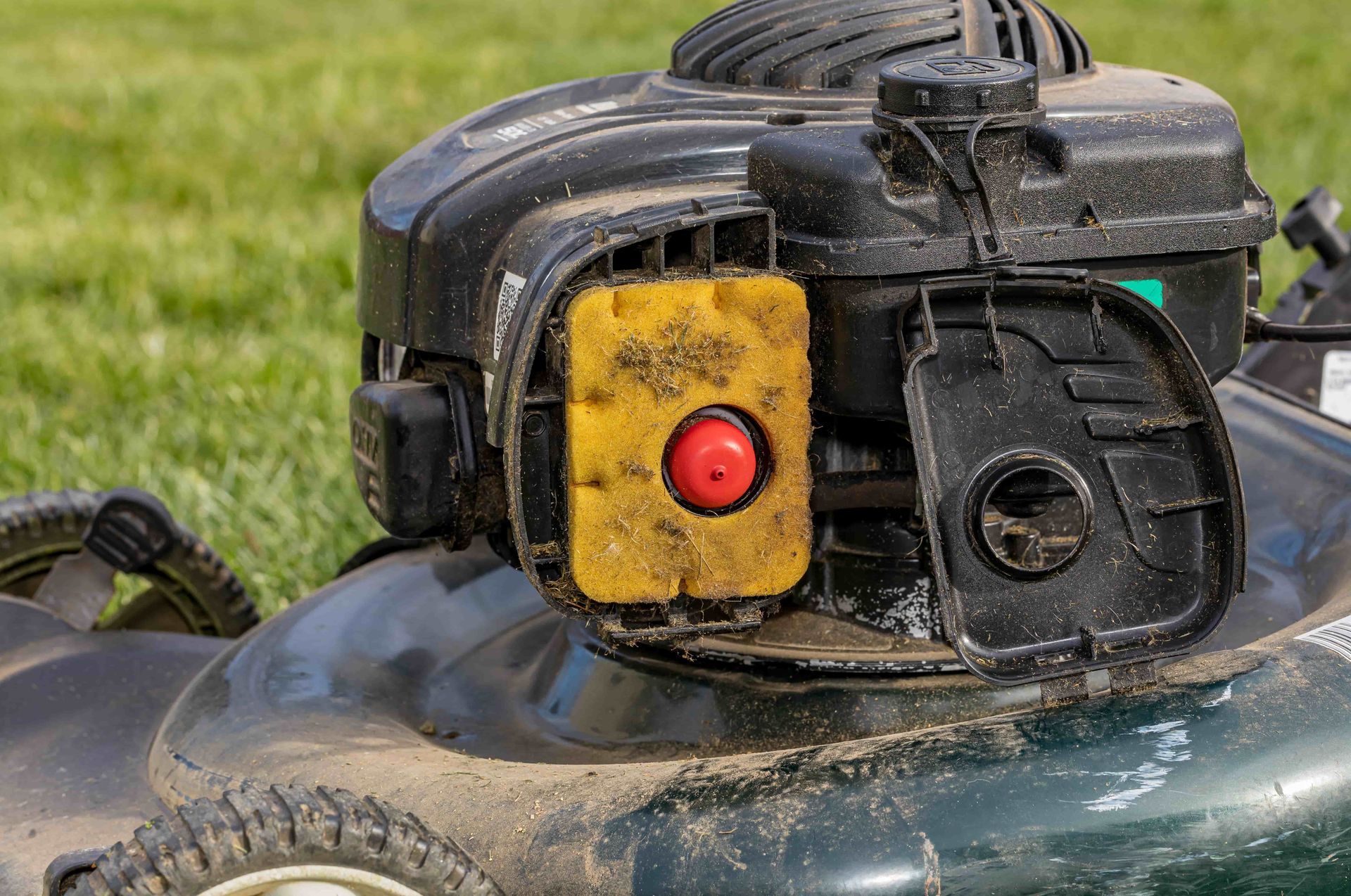 A close up of the engine of a lawn mower.